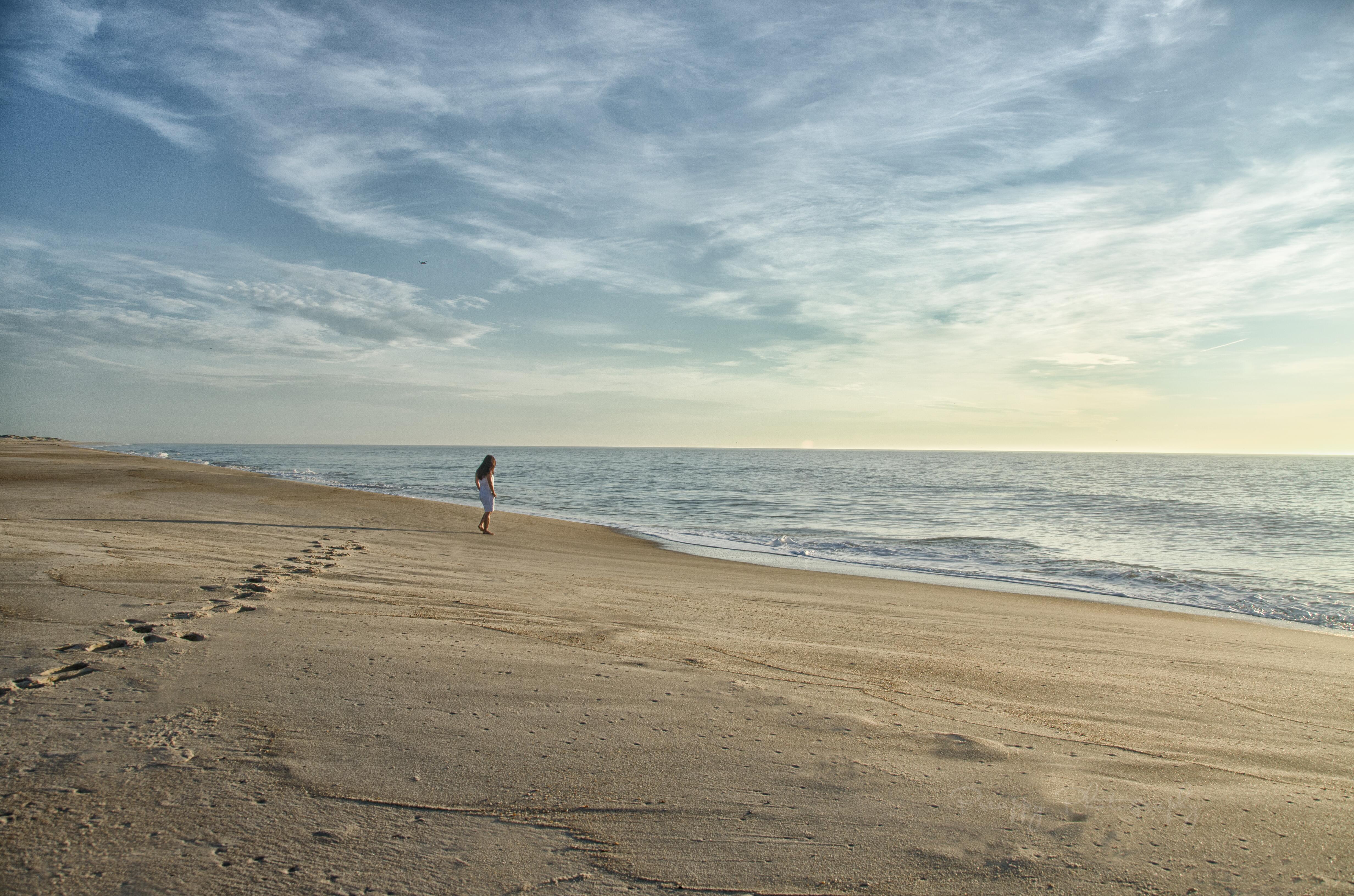 Image of a woman walking on a beach.