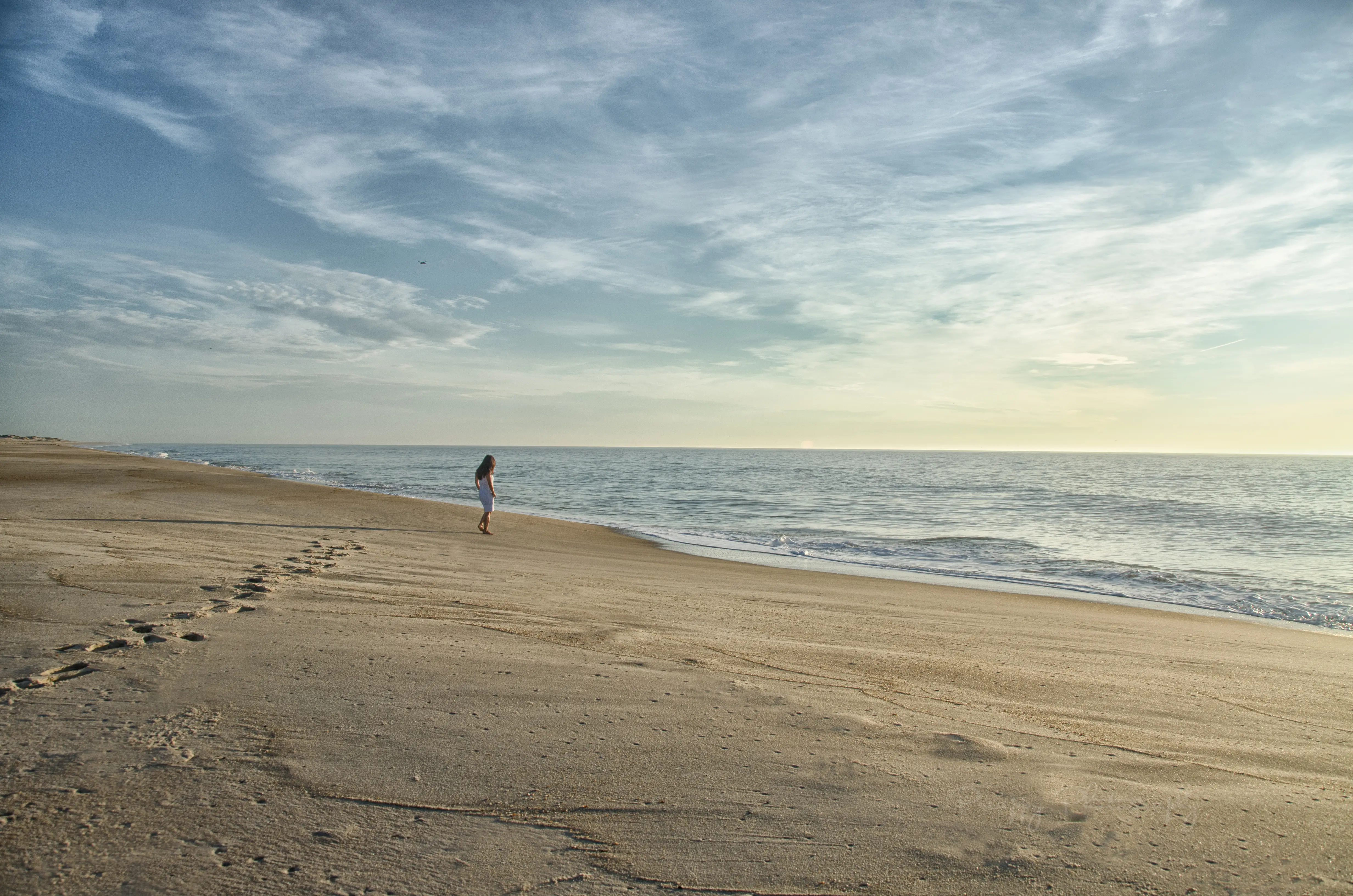 Image of a woman walking on a beach.