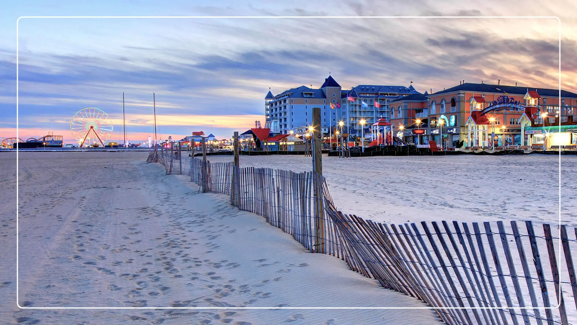 The sand of Ocean City, Maryland, with the boardwalk and pier in the background.
