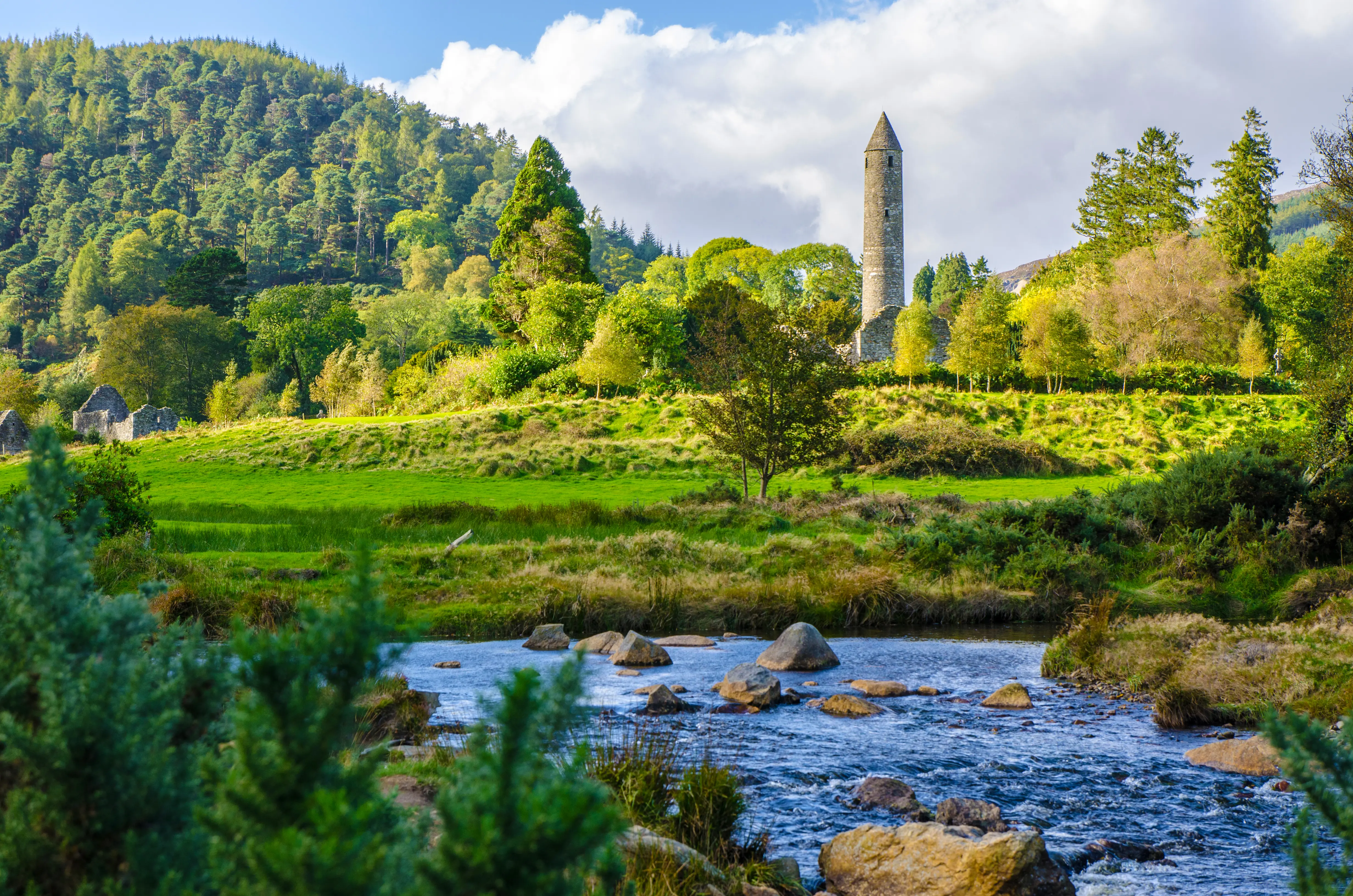 Dublin’s Round Tower in the old Glendalough monastic site in County Wicklow, river in forefront