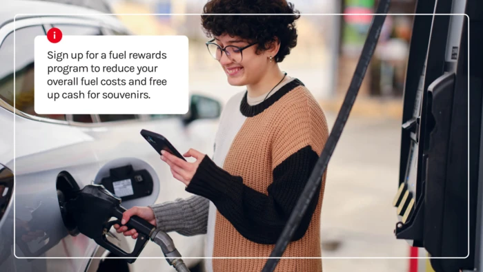 A driver using their fuel rewards program while filling up for gas during a road trip. 