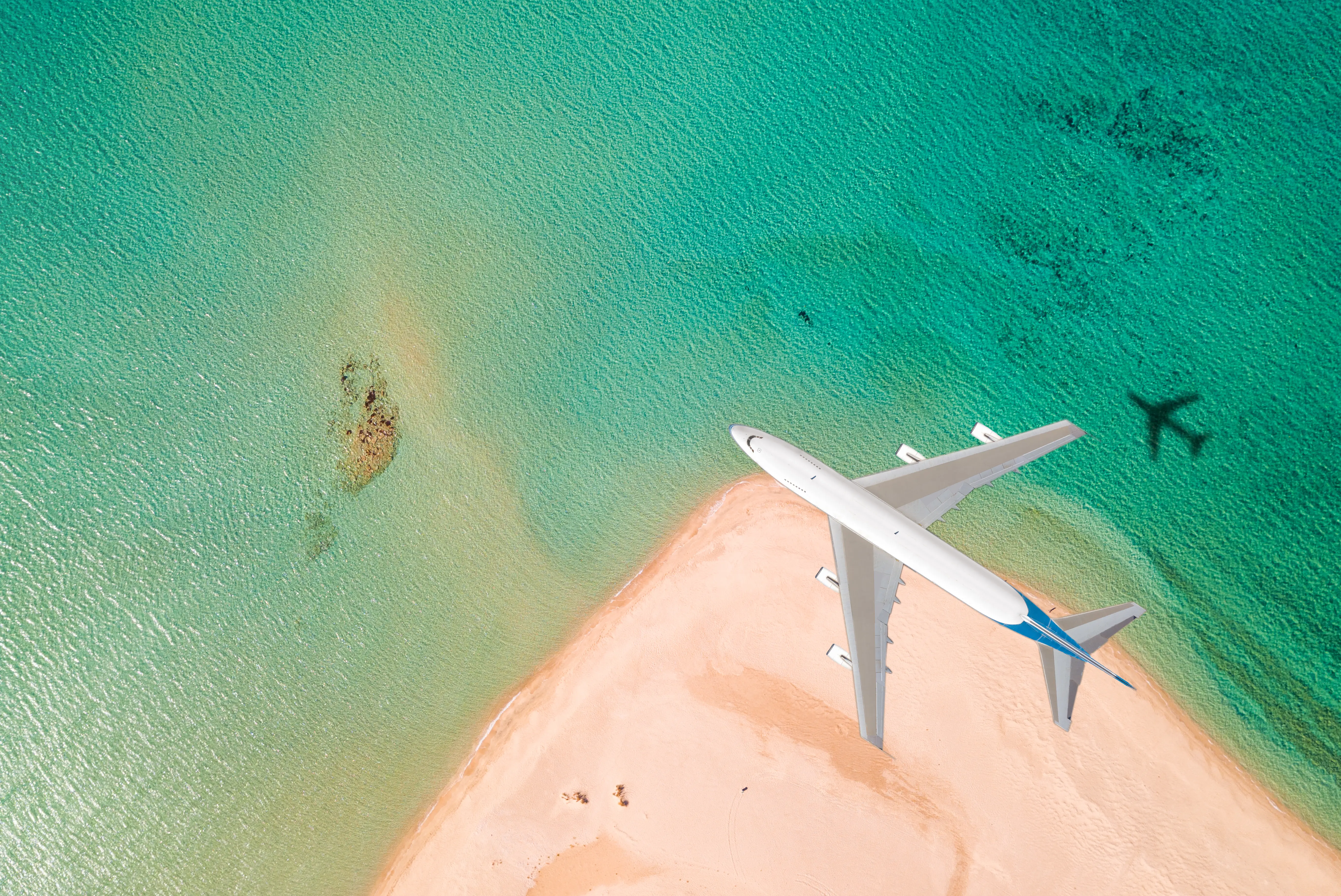 Image of a plane flying over a tropical beach.