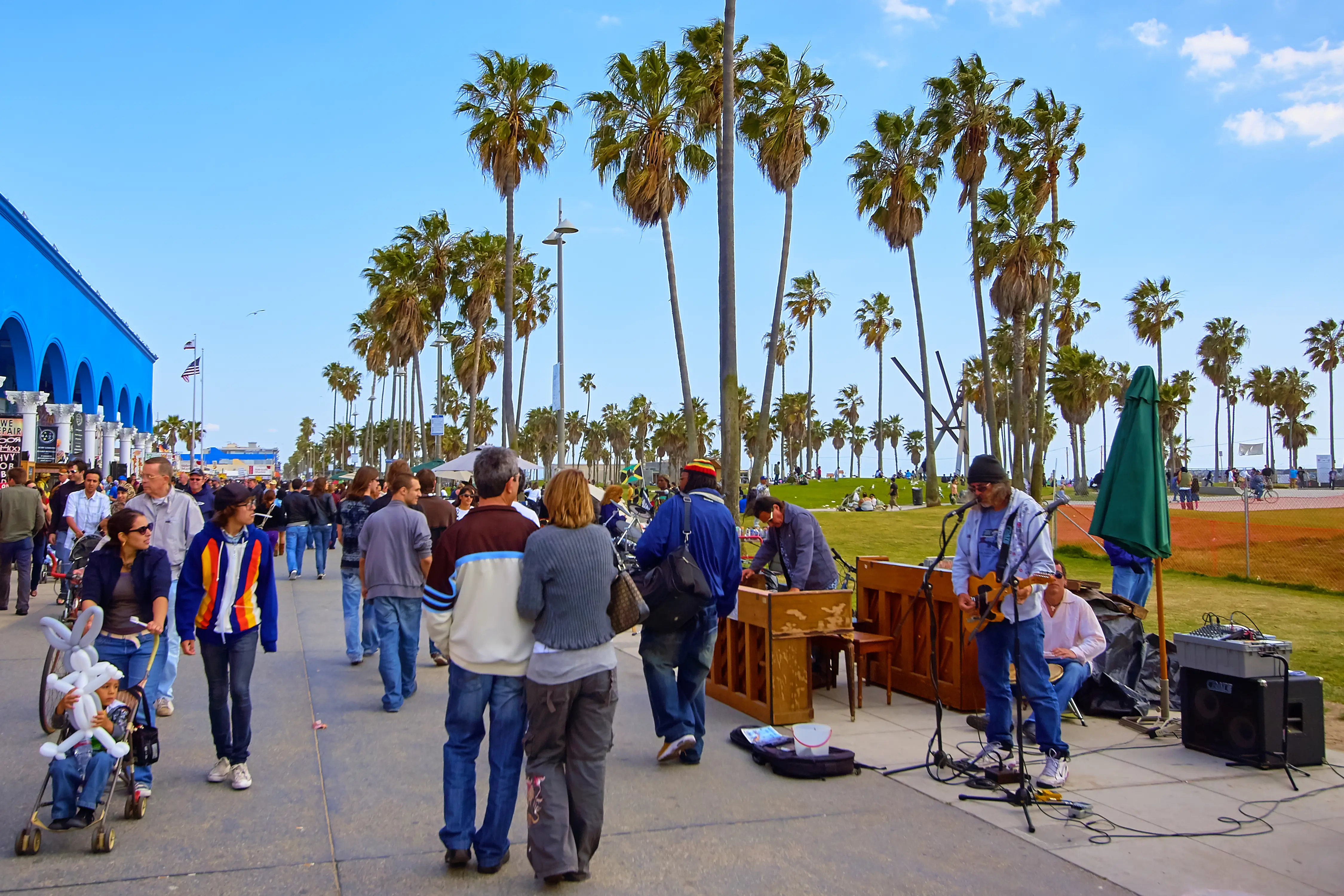 Image of people walking past the shops and performers of Venice Beach in Los Angeles, California.