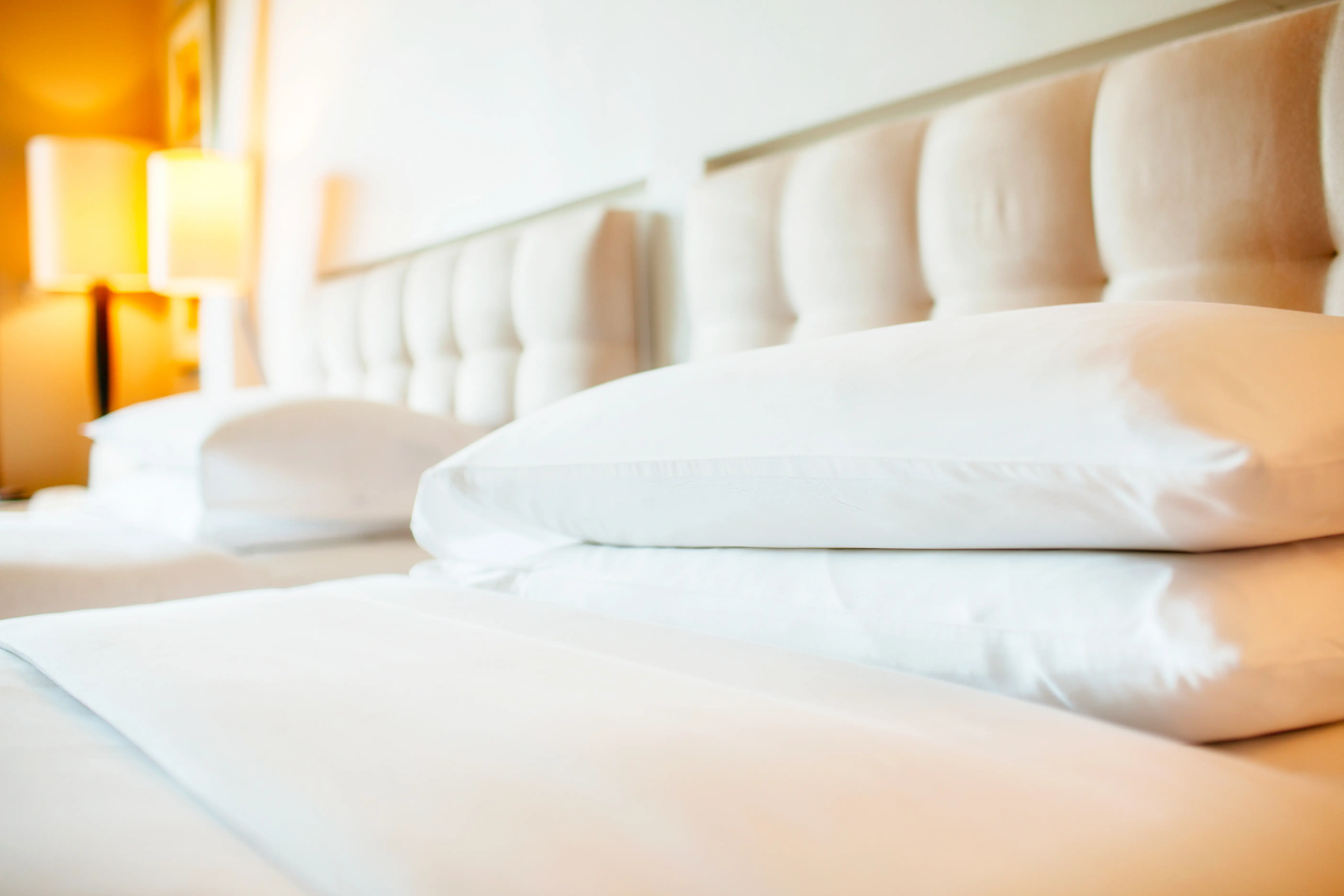 Hotel room with white pillows arranged on bed