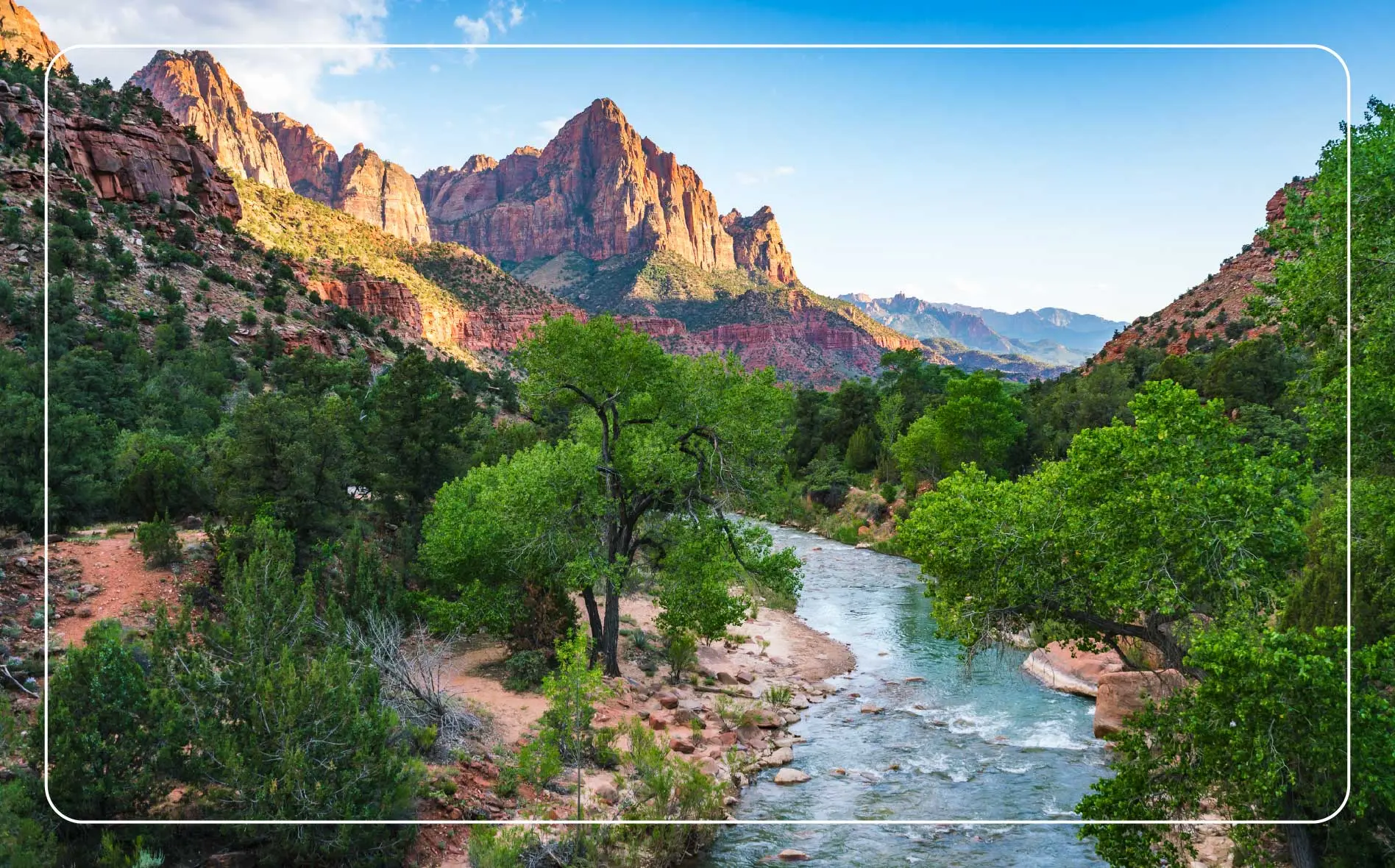 A river flows through the rock formations and alongside the trails of Zion National Park.