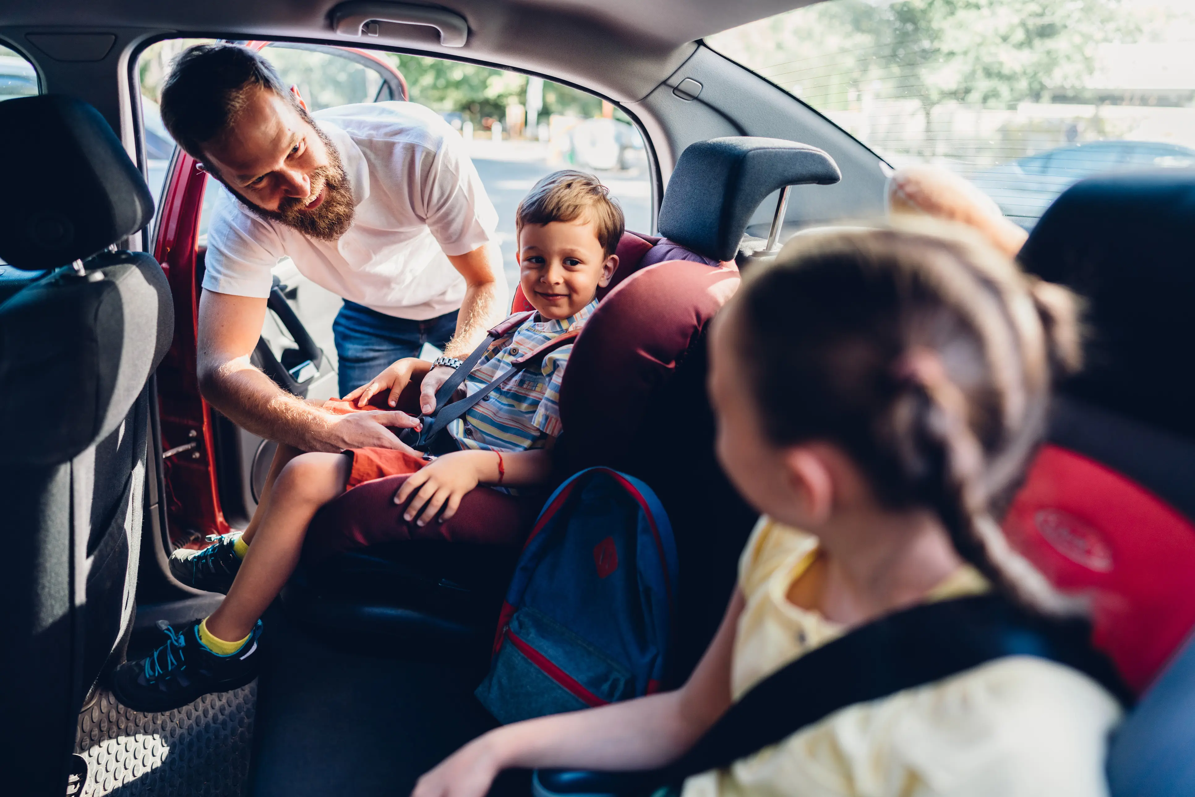Father caring his kids to be safe during road trip.