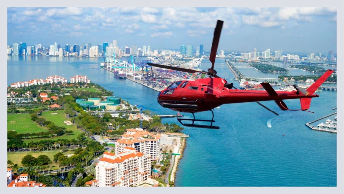 A helicopter is shown flying over a city, alluding to the experience gift idea of a helicopter tour. 