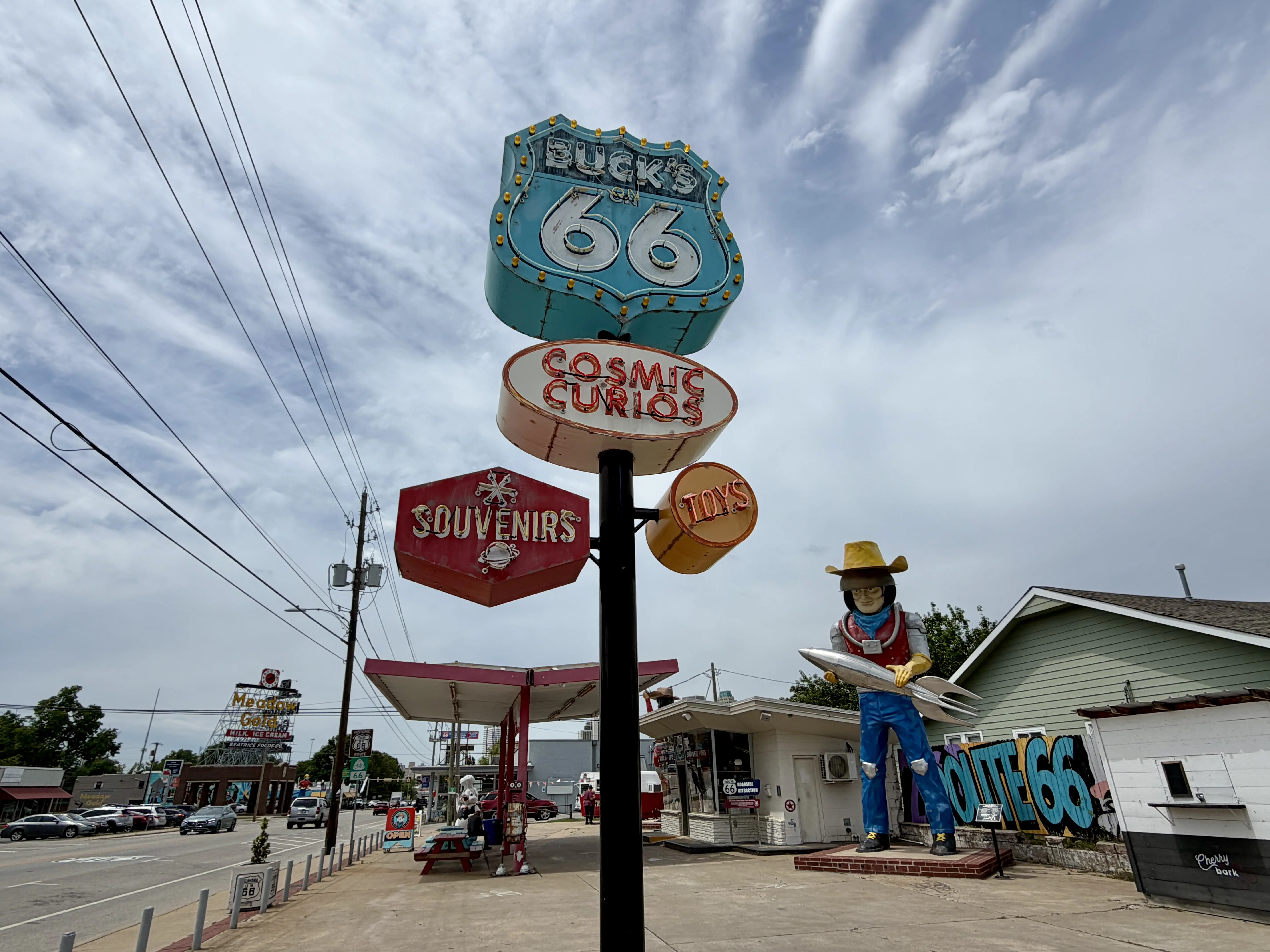 Neon sign for gas station and store Buck's on 66 with the oversized Atomic Cowboy statue in the background