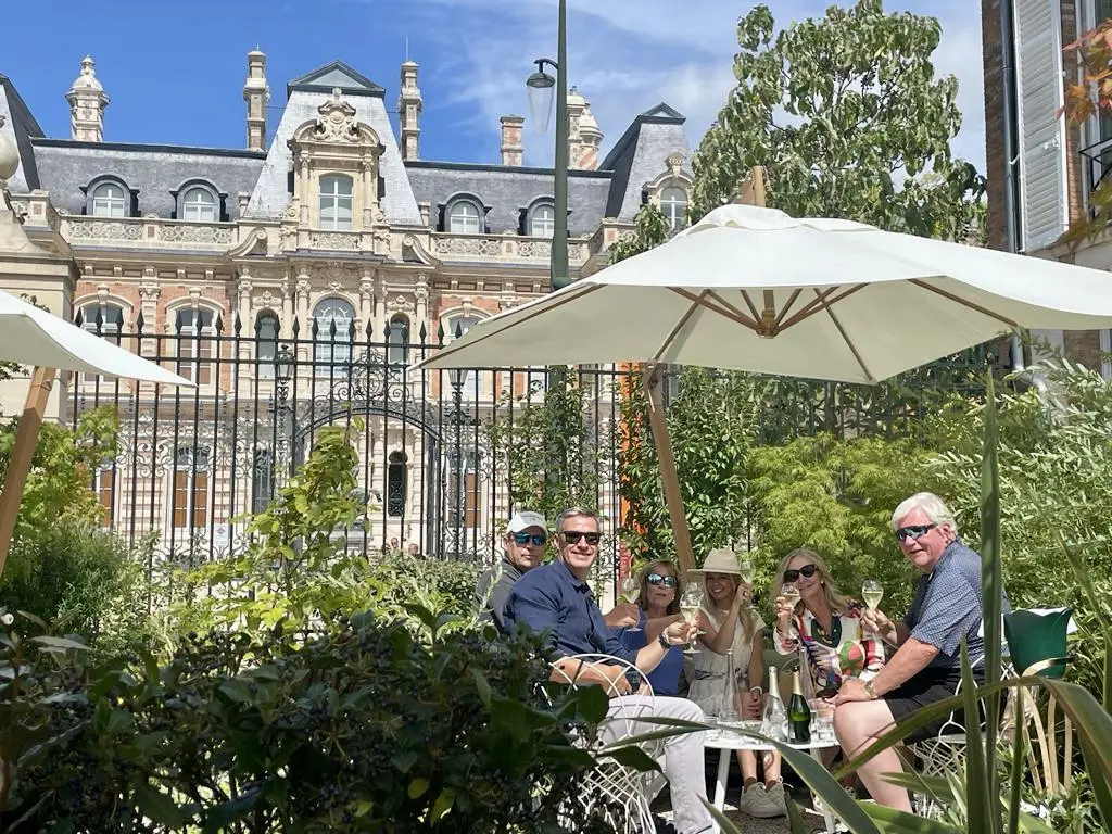 Image of people enjoying champagne at the Avenue de Champagne in Reims, France.