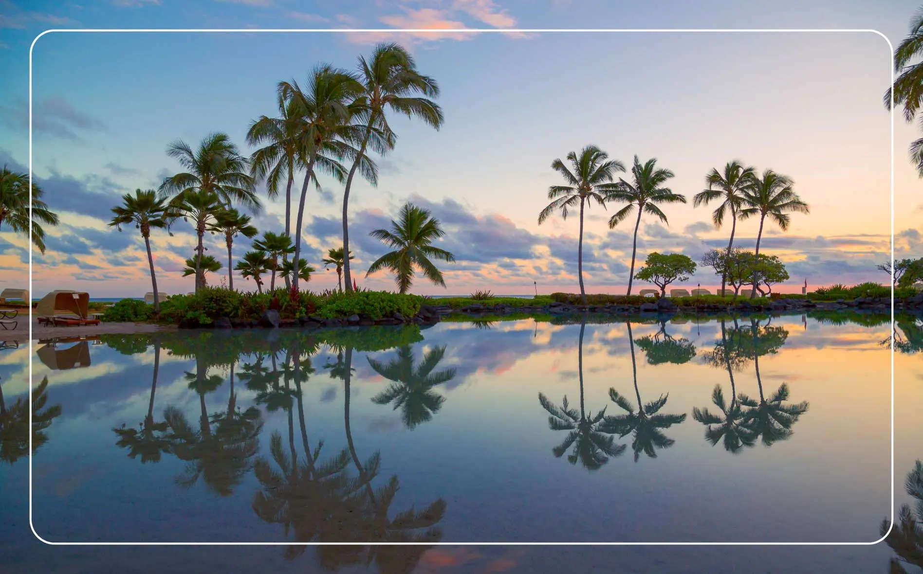Calm waters reflect the palm trees at Poipu Beach on Kauai, Hawaii.