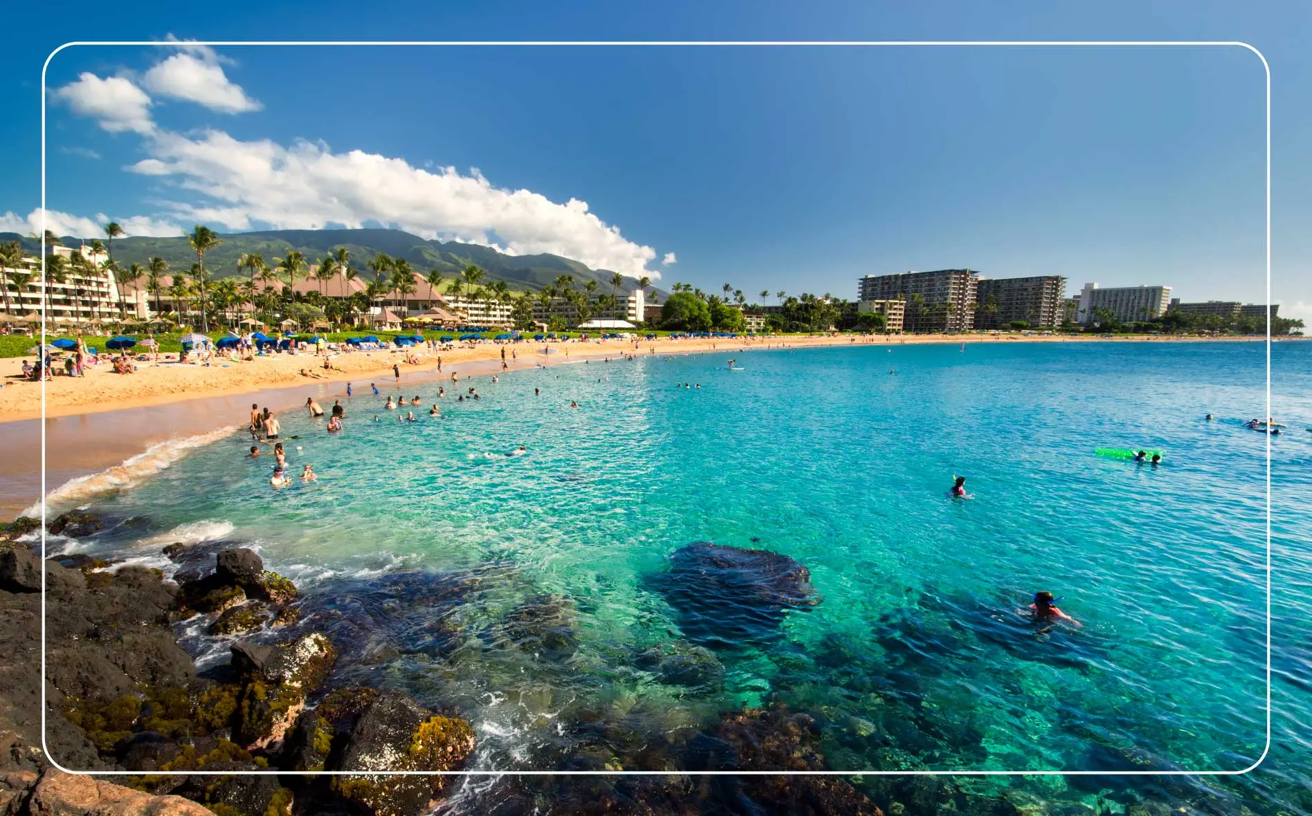 People enjoy the water at Kaʻanapali Beach on Maui, Hawaii.