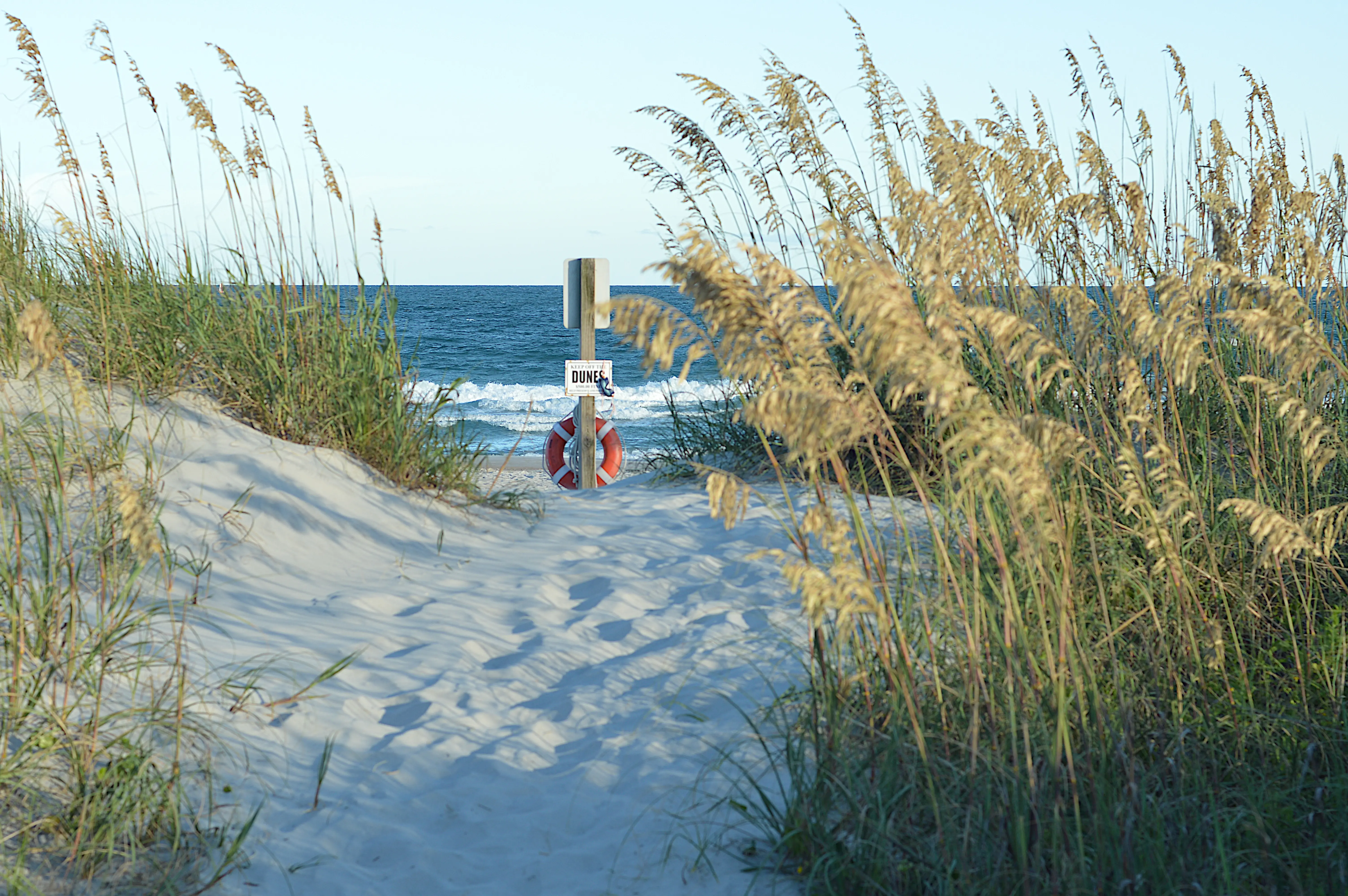 Image of a life preserver in the sand dunes of Topsail Beach, North Carolina.