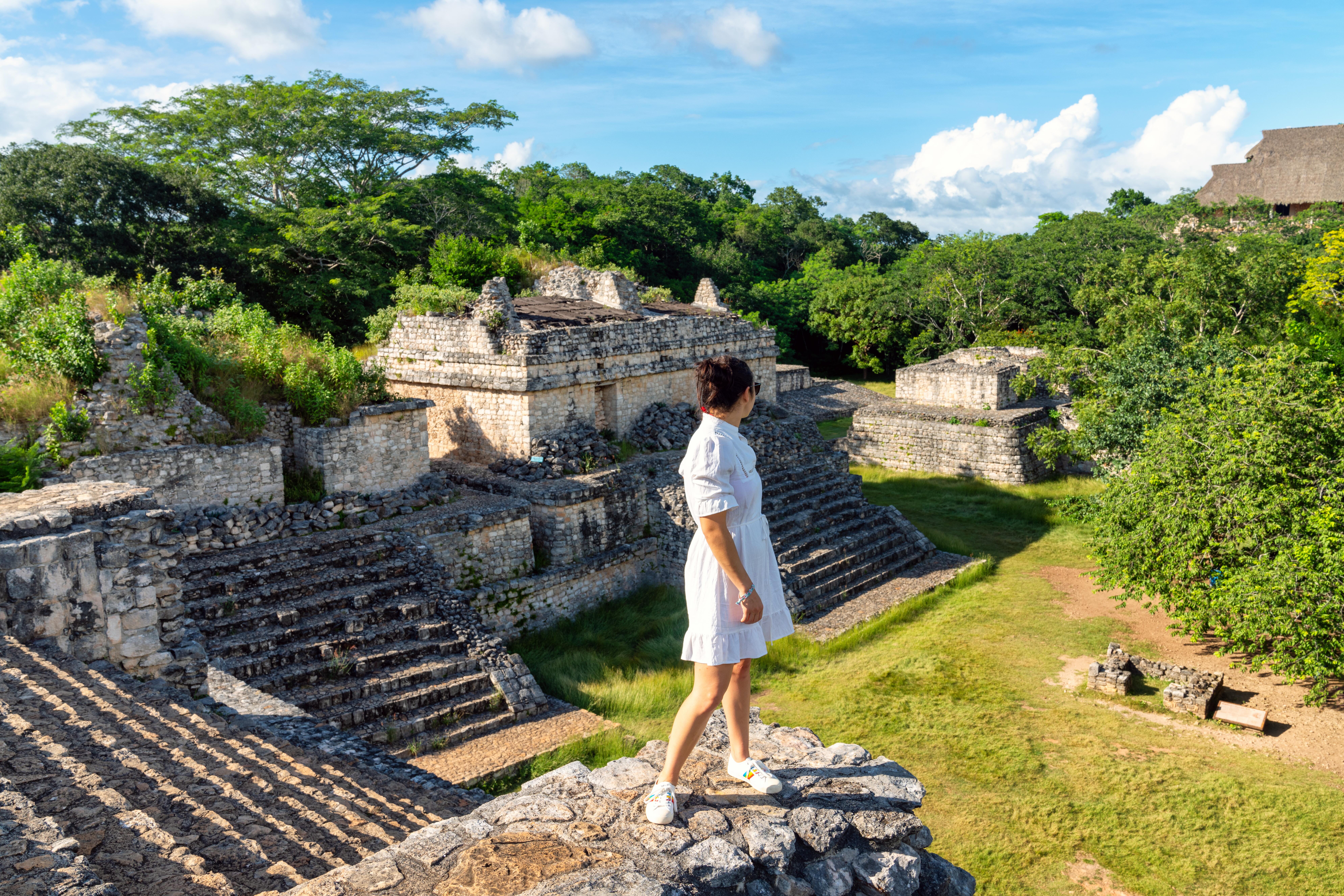 Woman in white dress viewing Mayan ruins in Yucatan, Mexico