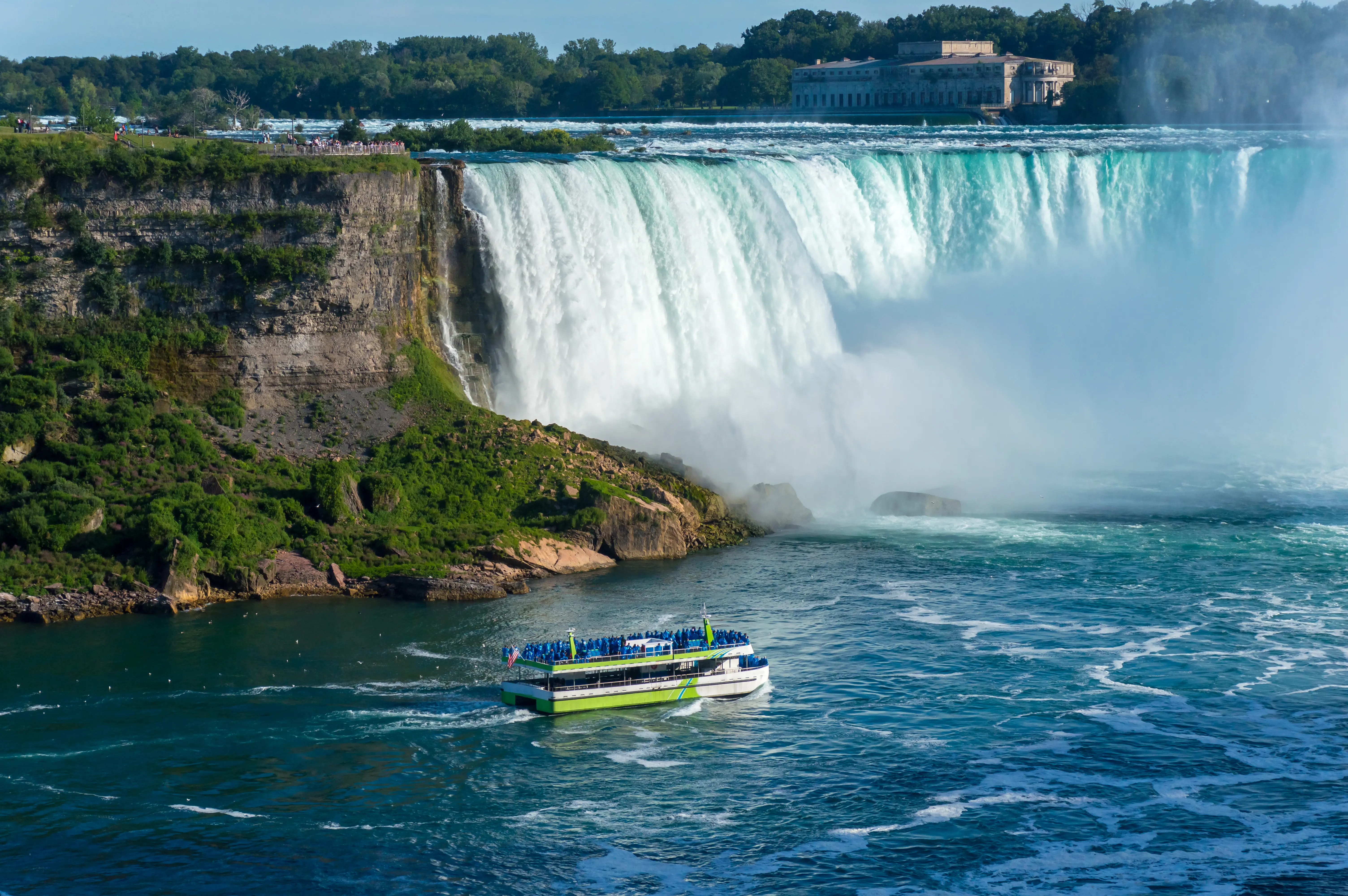 Maid of the Mist boat tour approaching the waterfall on a summer day, Niagara Falls