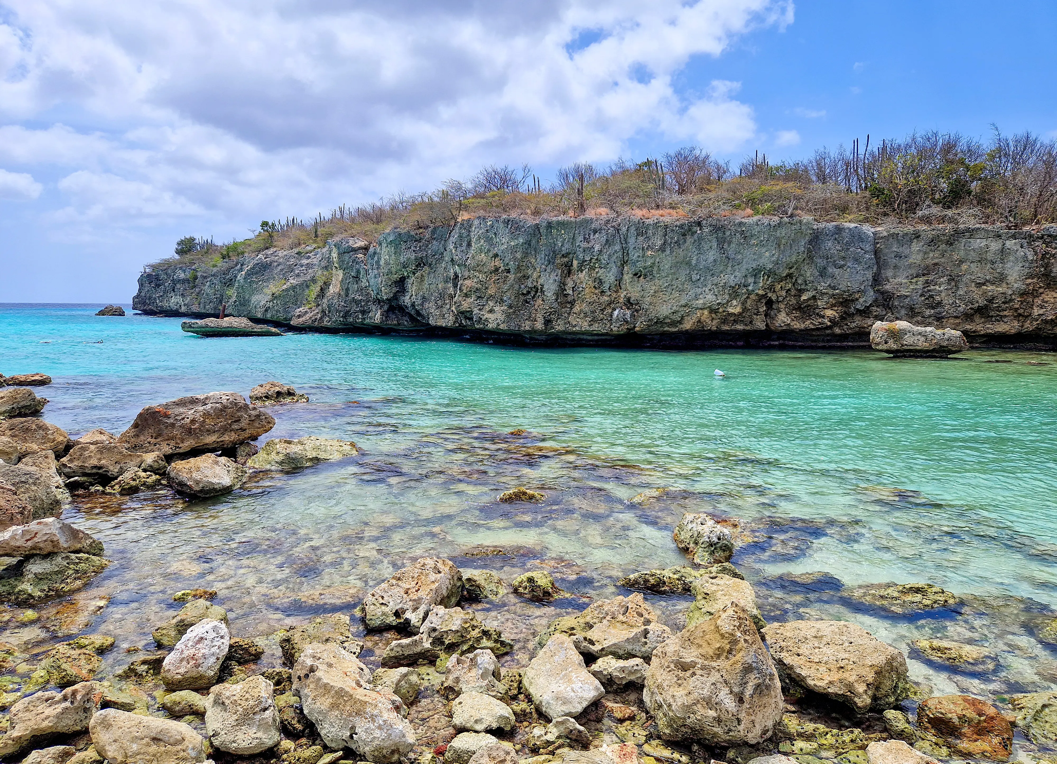 Image of the sea and rocky cliffs at Daaibooi beach, Curacao.
