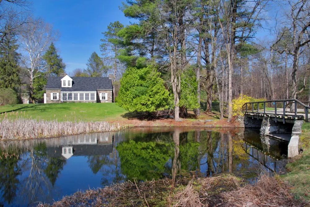 The Stone Cottage with a pond in front at Eleanor Roosevelt National Historic Site.