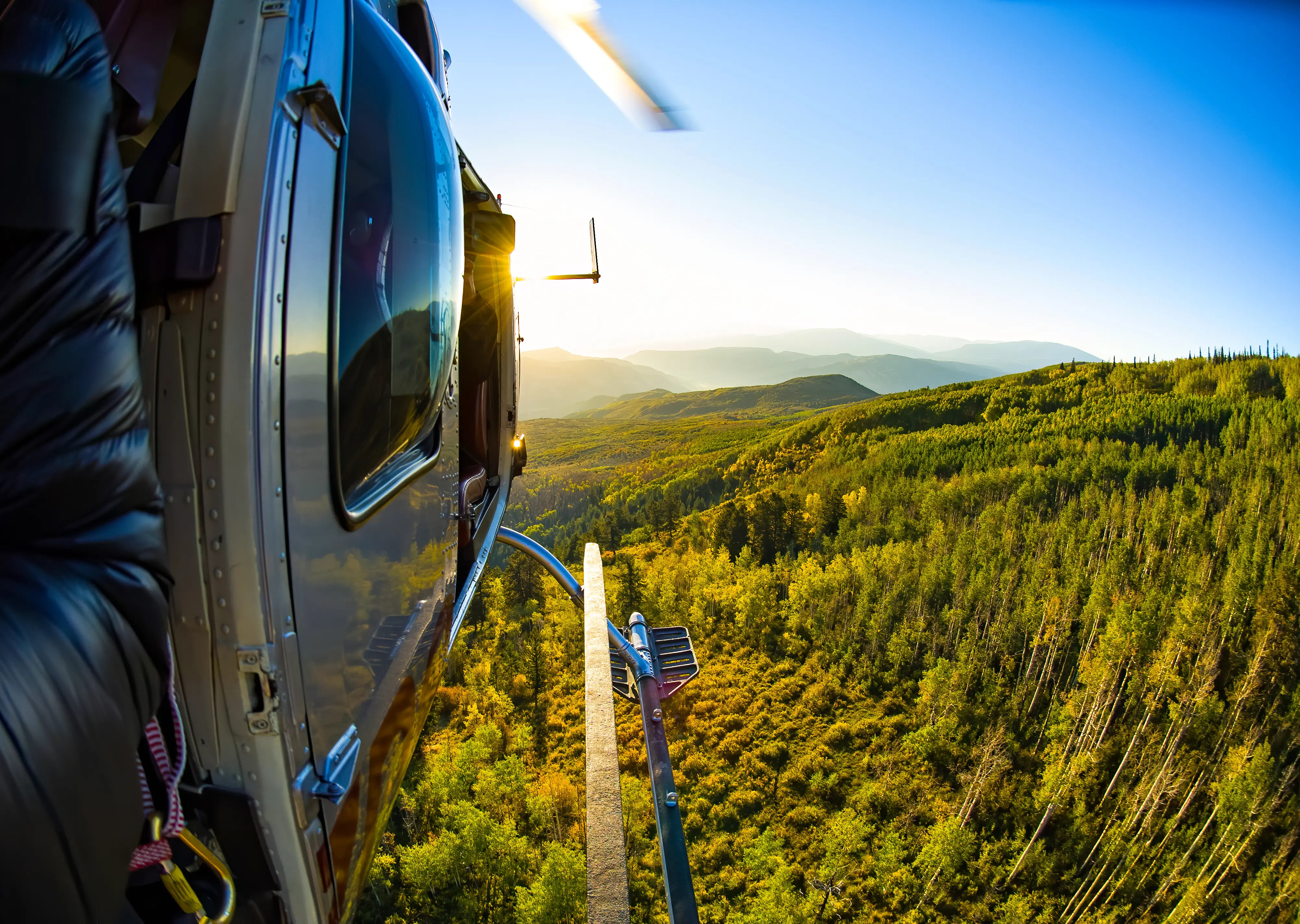 Helicopter flying high above fall autumn foliage