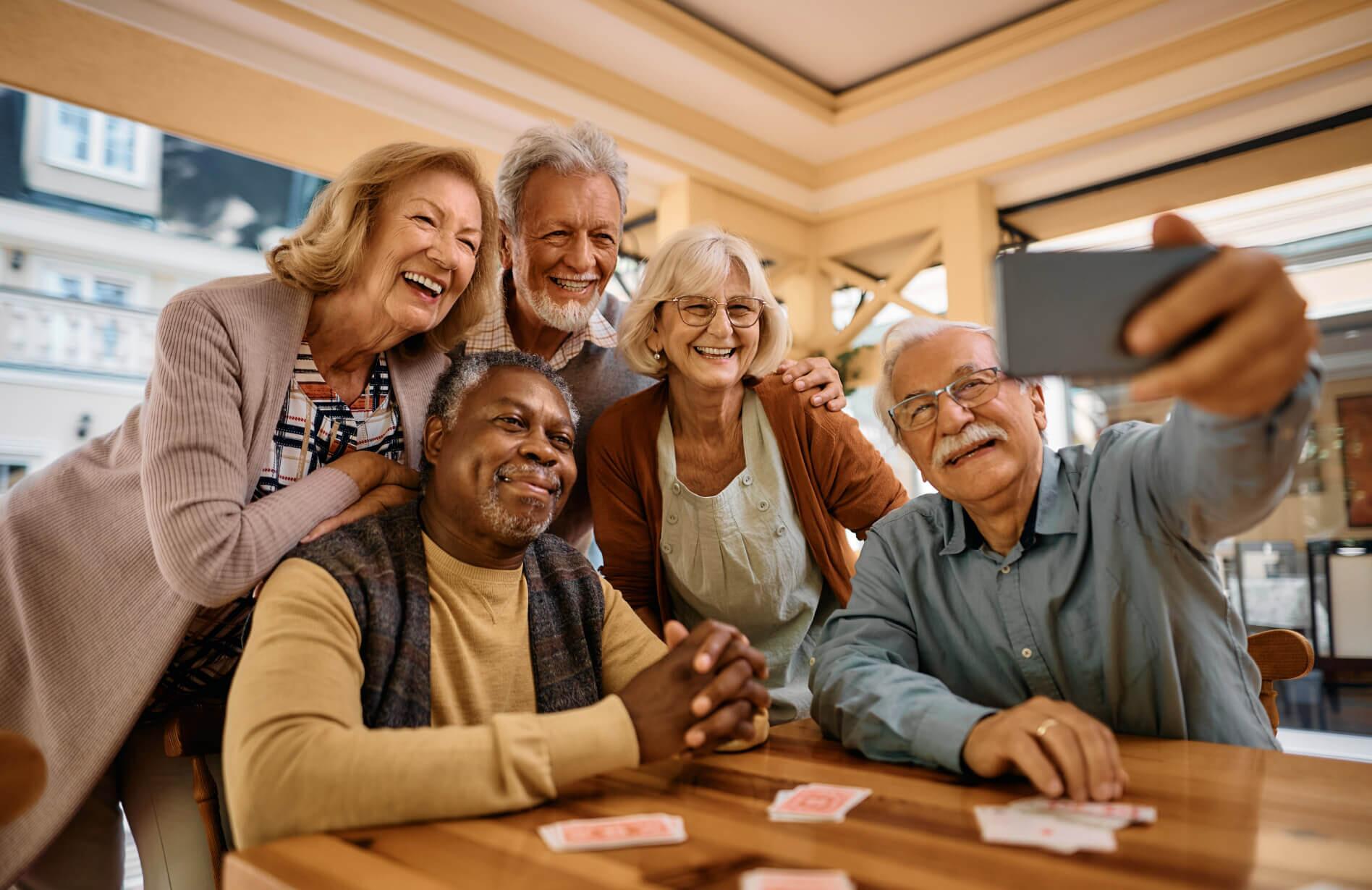 A group of seniors taking a selfie together on a phone.
