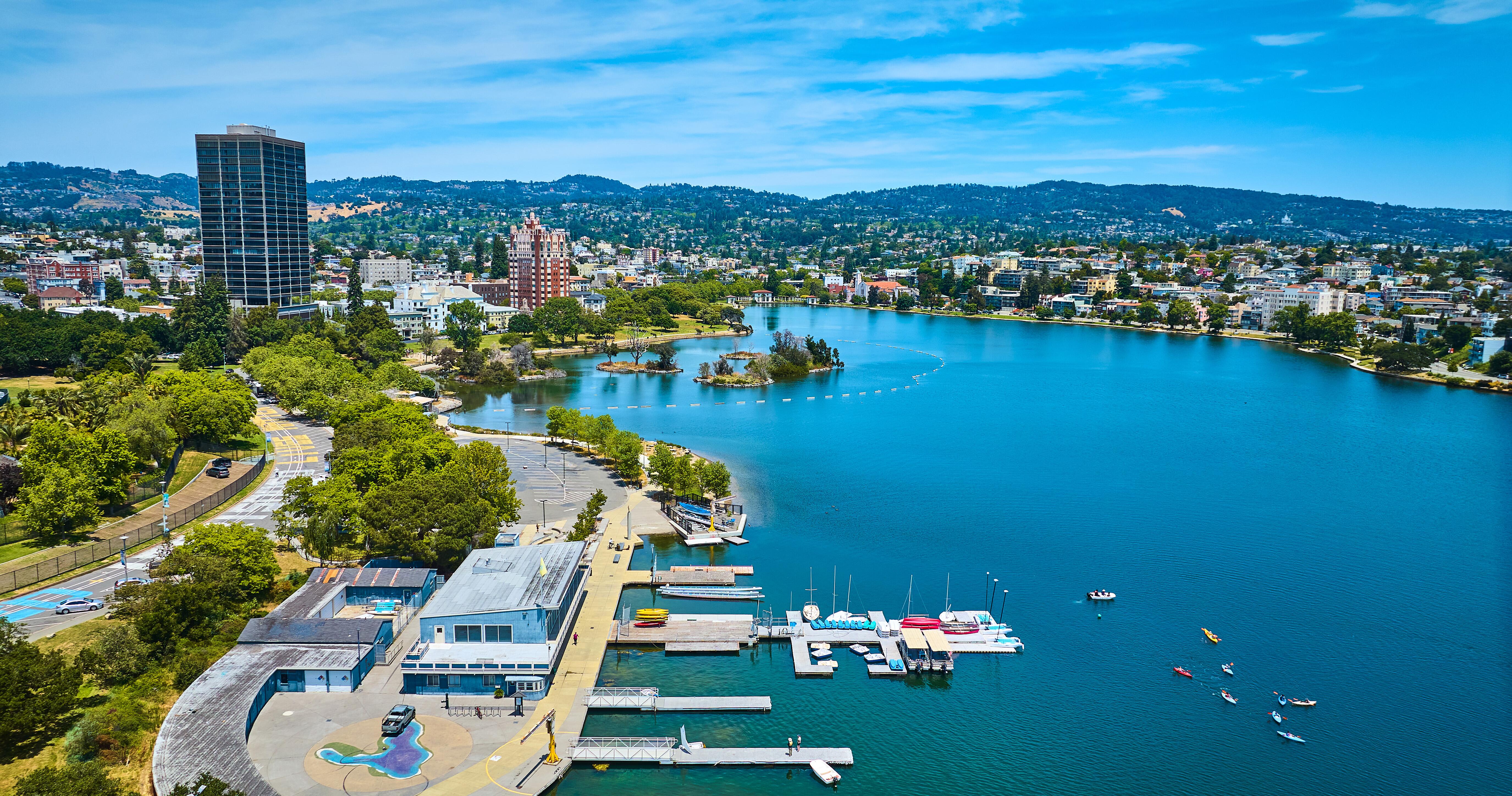 Aerial boating center on Lake Merritt with Pelican Island in distance with buildings along shore.