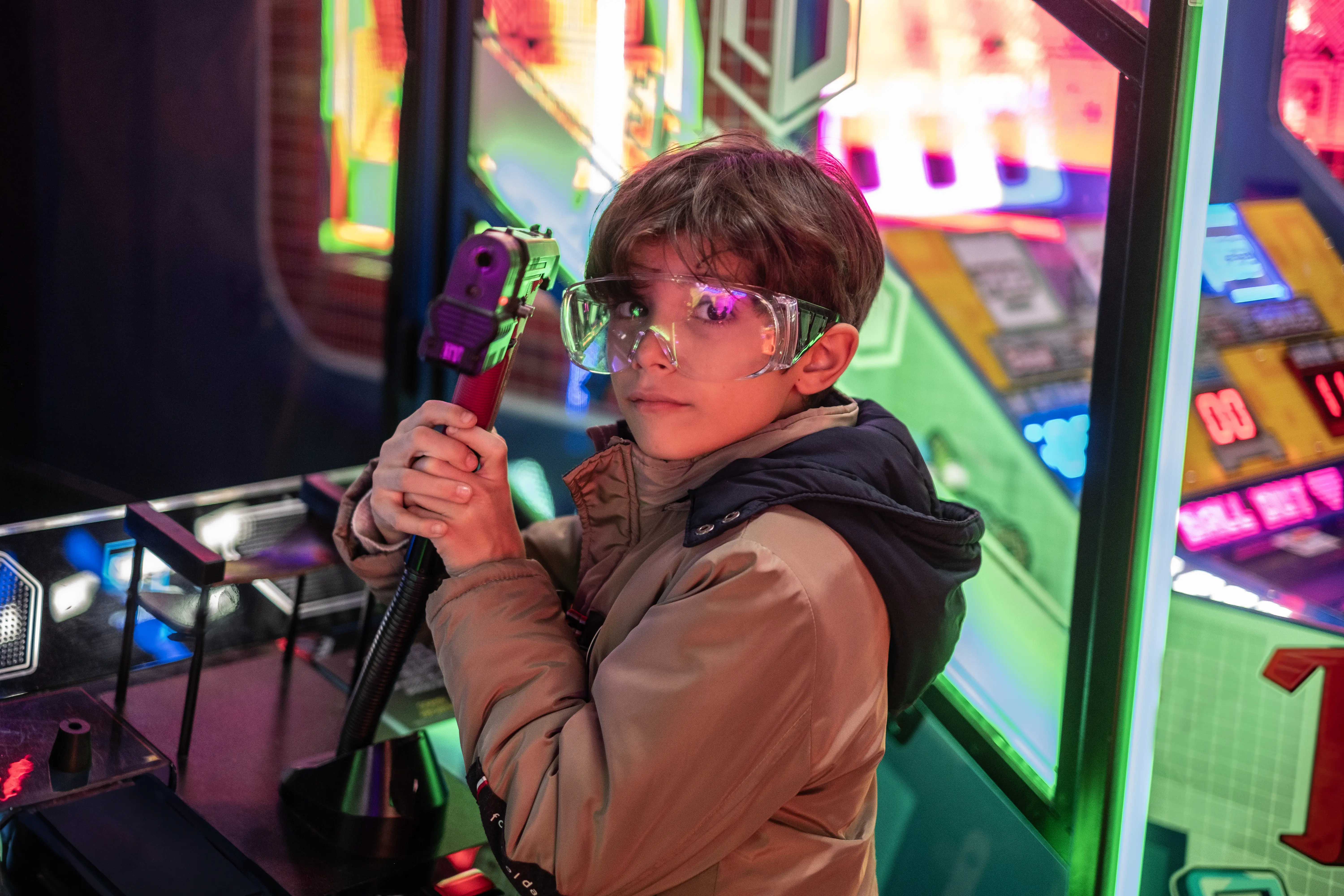 Image of a child playing a virtual shooting game at an arcade.