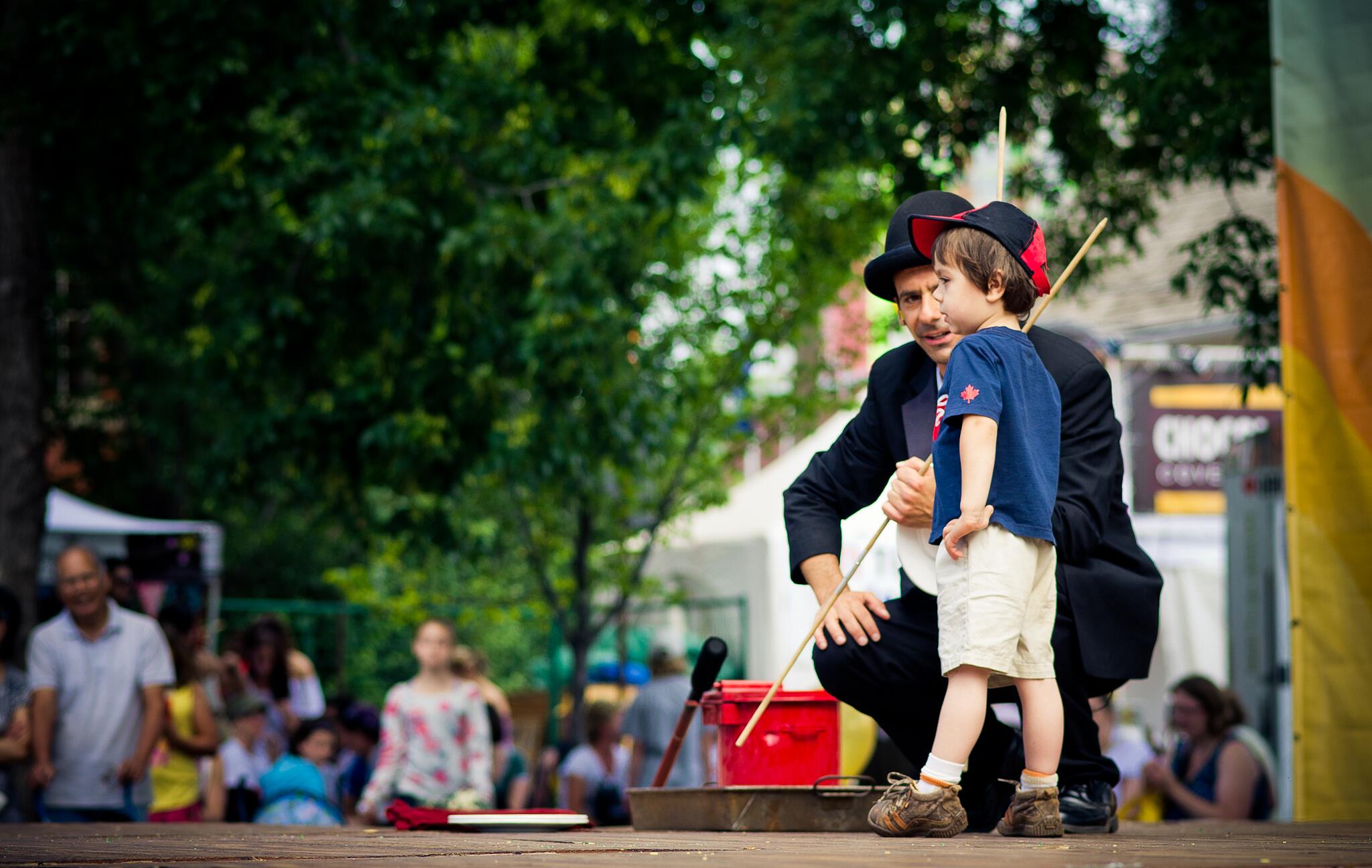 A child shares the stage with a circus performer in Monntreal