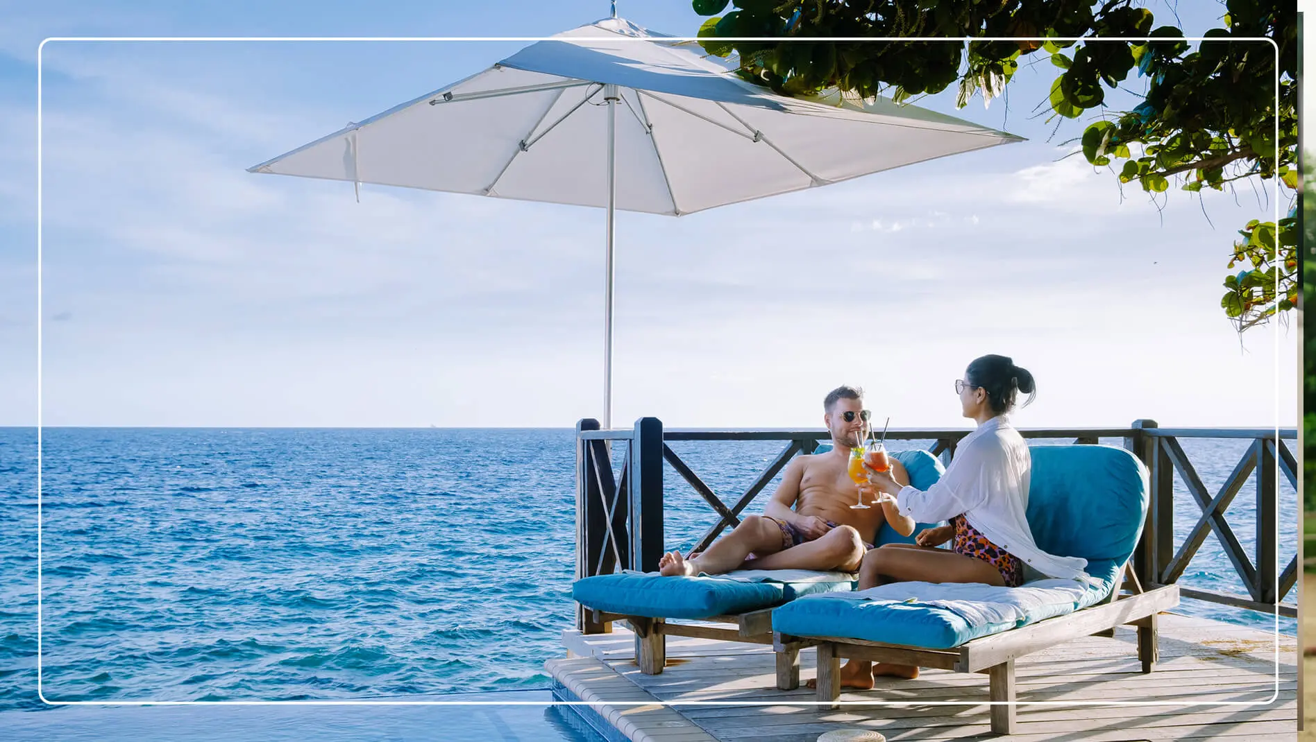 A couple lounging by the ocean at a resort.