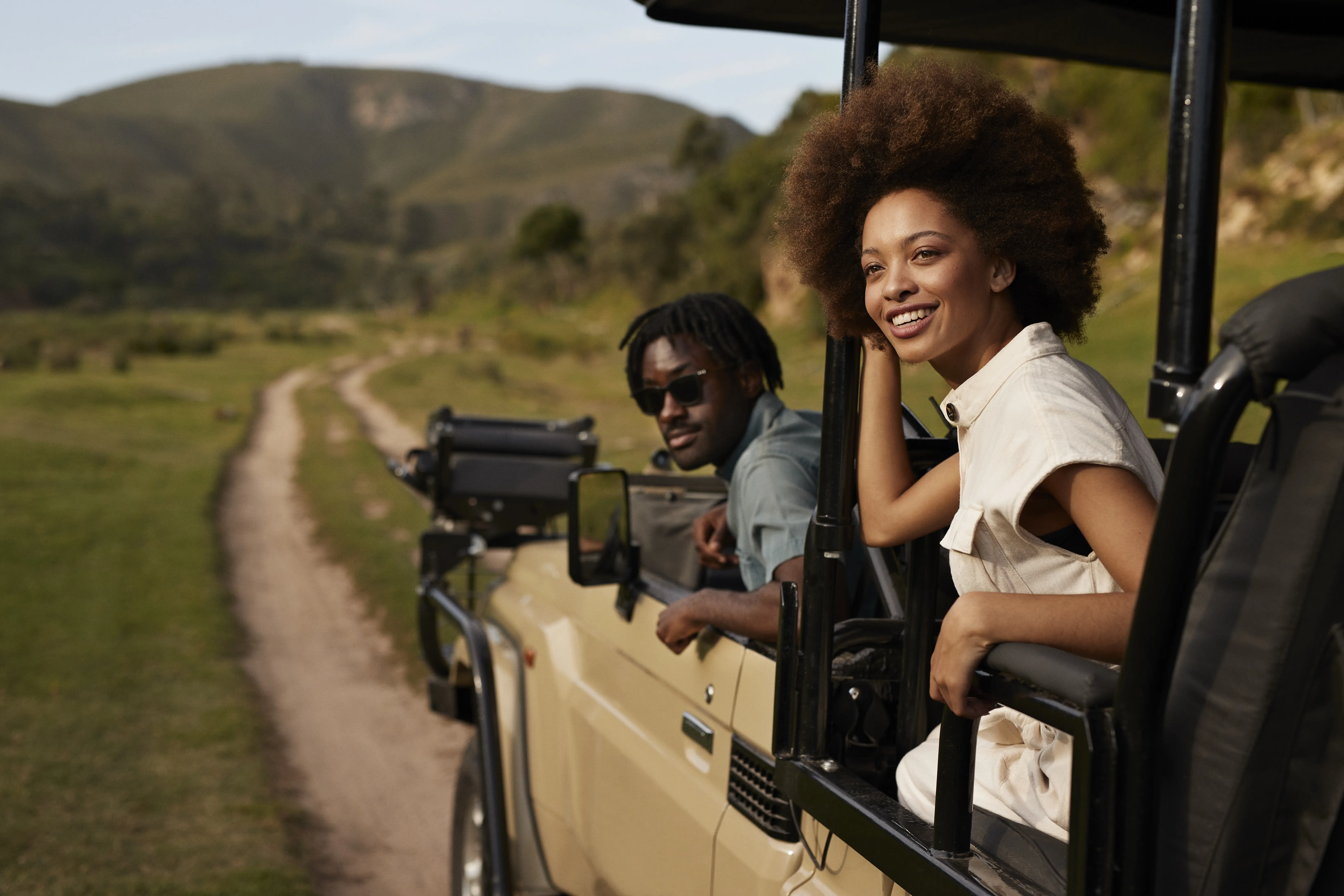 Image of guests on board safari vehicles, observing the wilderness surroundings.