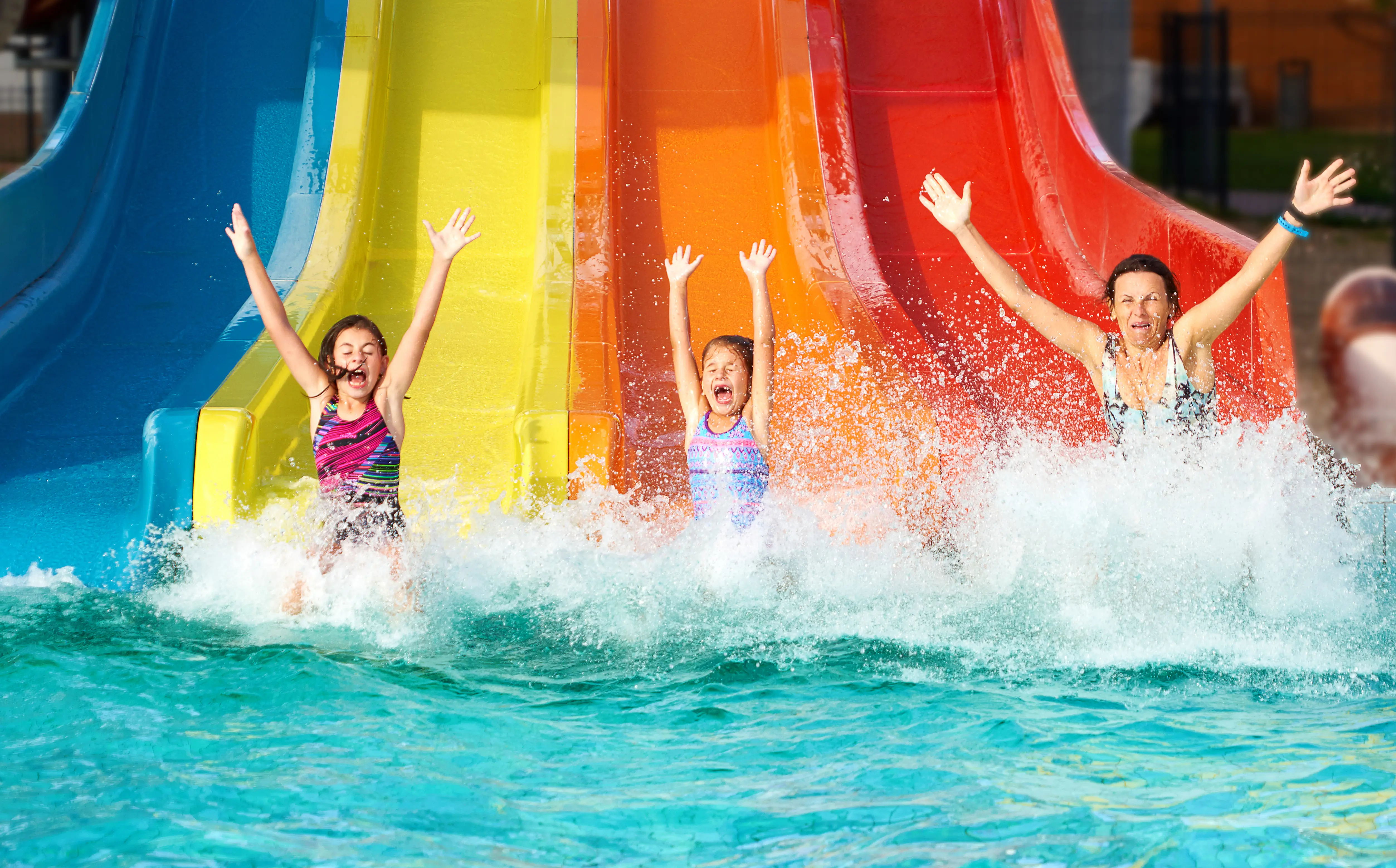 Girls who slipped on the slide, and when they fall into the water they have raised hands and eyes closed with emotion and enthusiasm