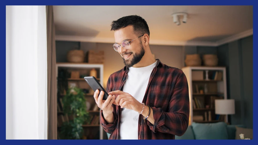 A man using his phone in his home. 