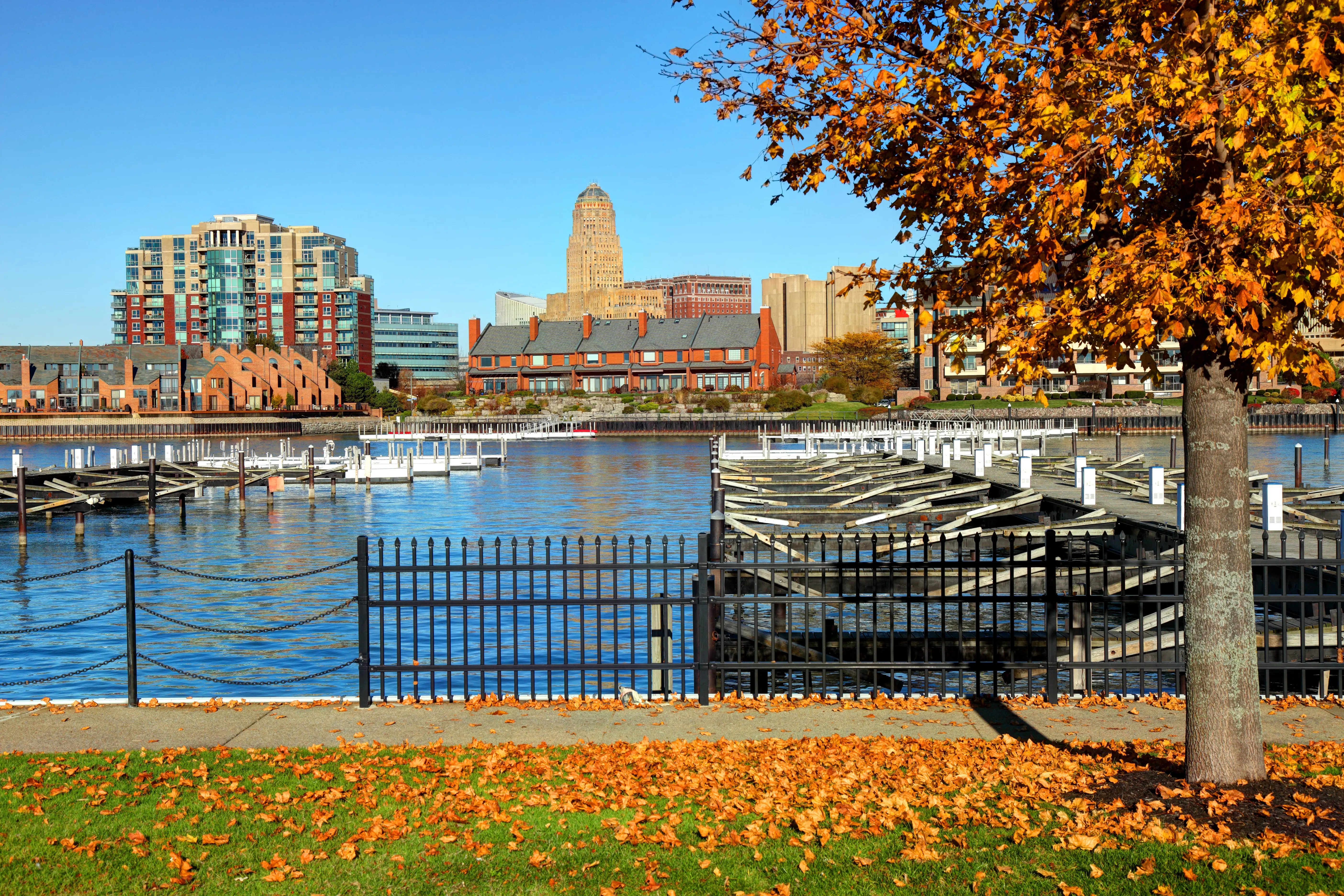 Autumn day along the Canalside waterfront area with river, docks and Buffalo city skyline in the distance, New York