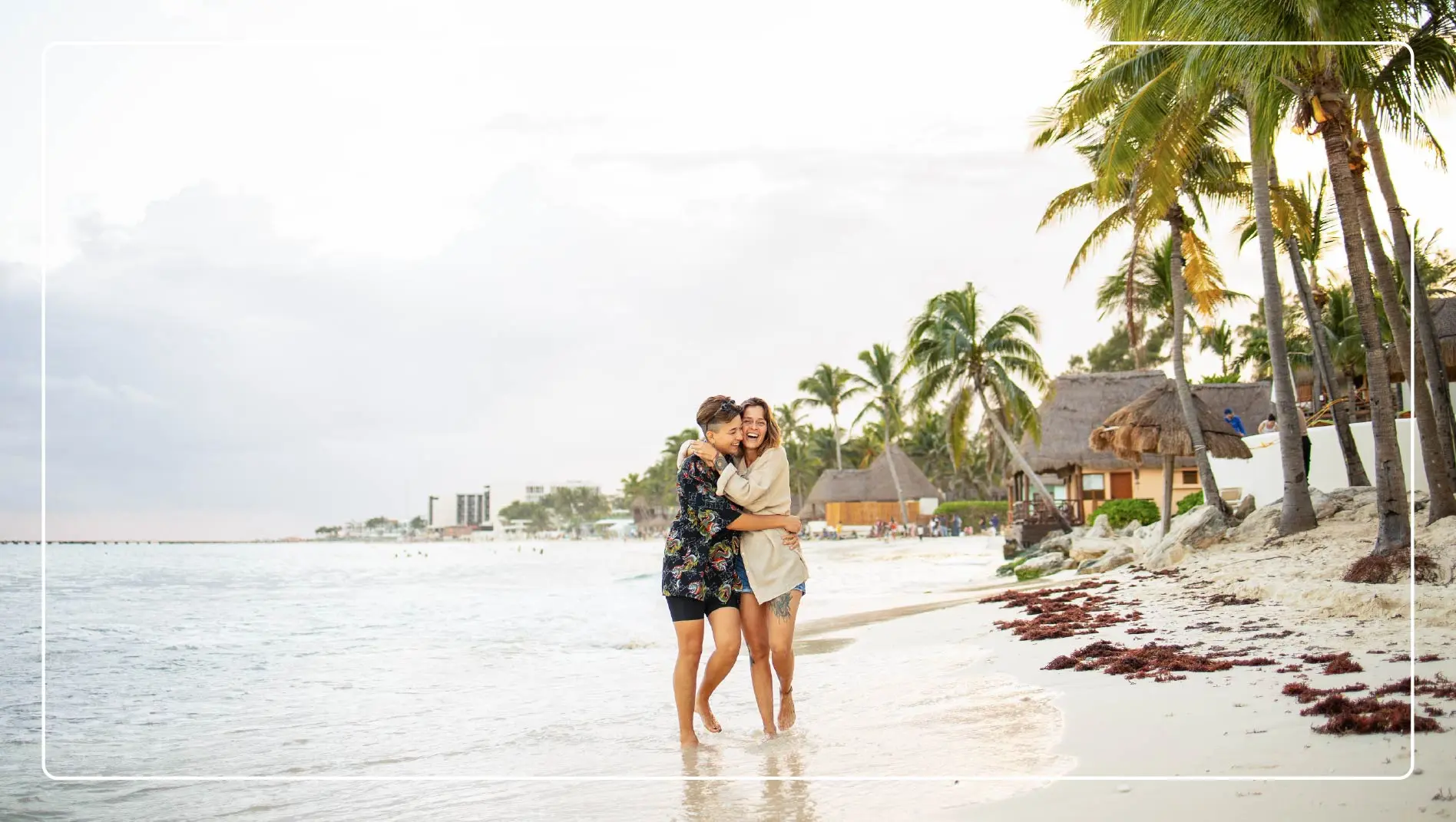 A couple hugs while walking along the shore in Mexico.