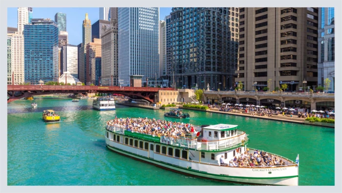 A large boat filled with people glides across the water during a guided historical tour. 