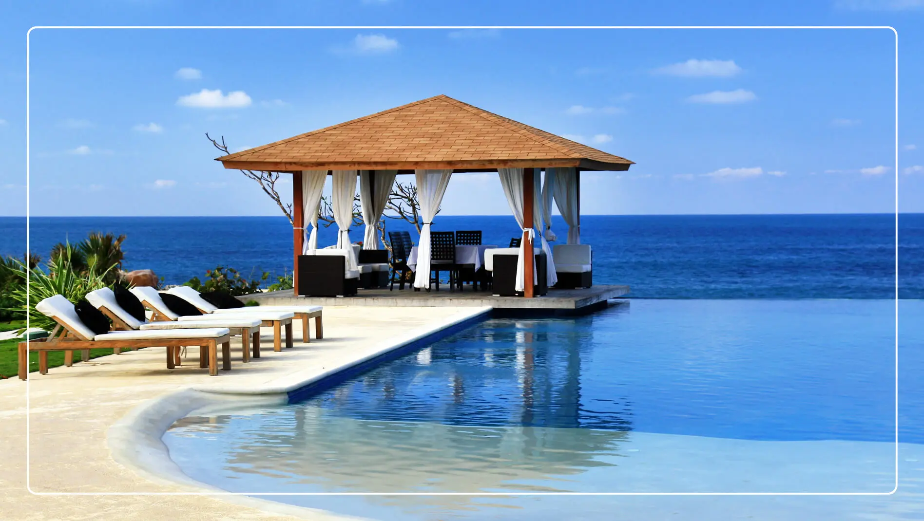 A gazebo overlooks an infinity pool with the ocean in the background.