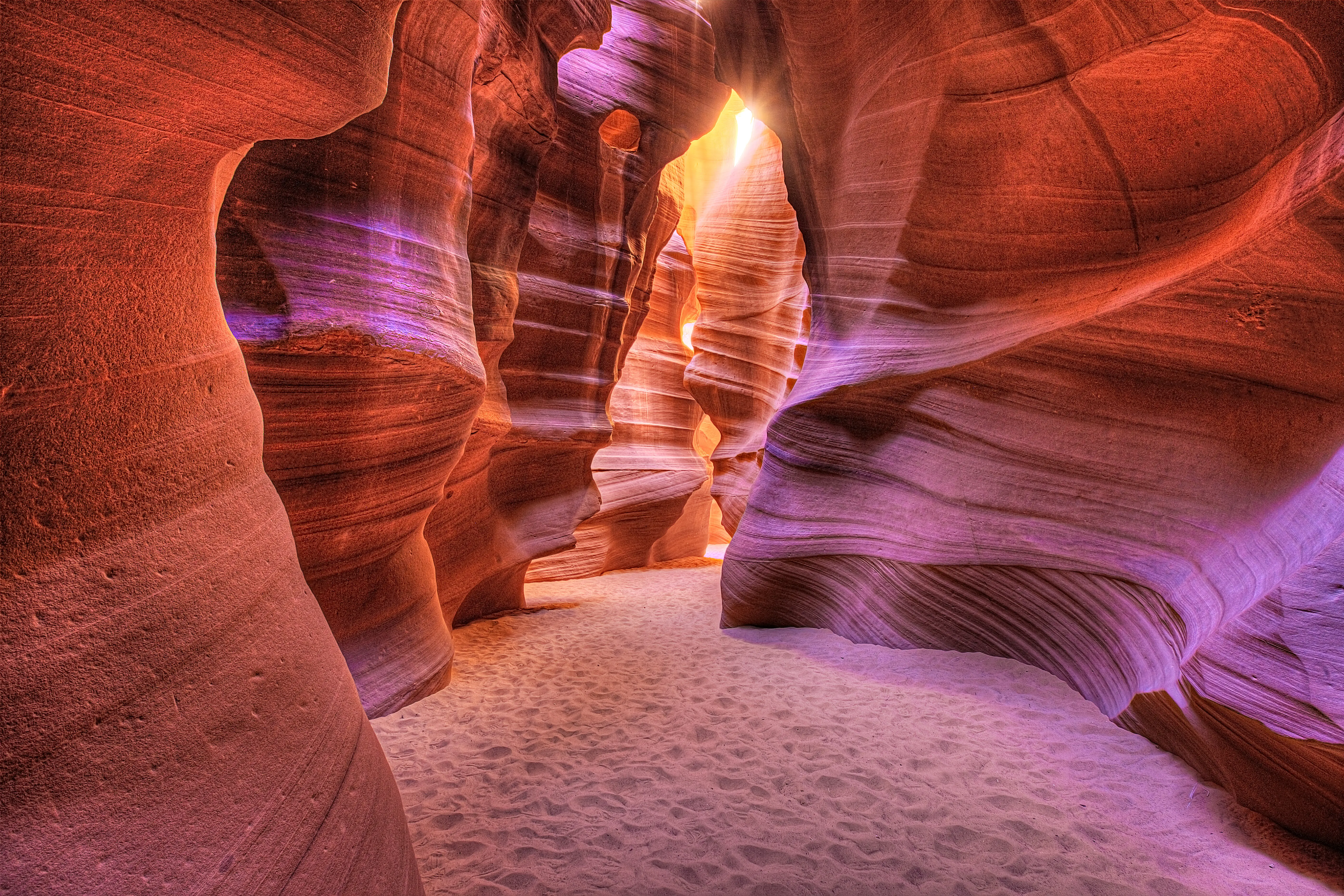 Glowing orange and pink cave walls from ray of sun shining into Antelope Slot Canyon, Page, Arizona