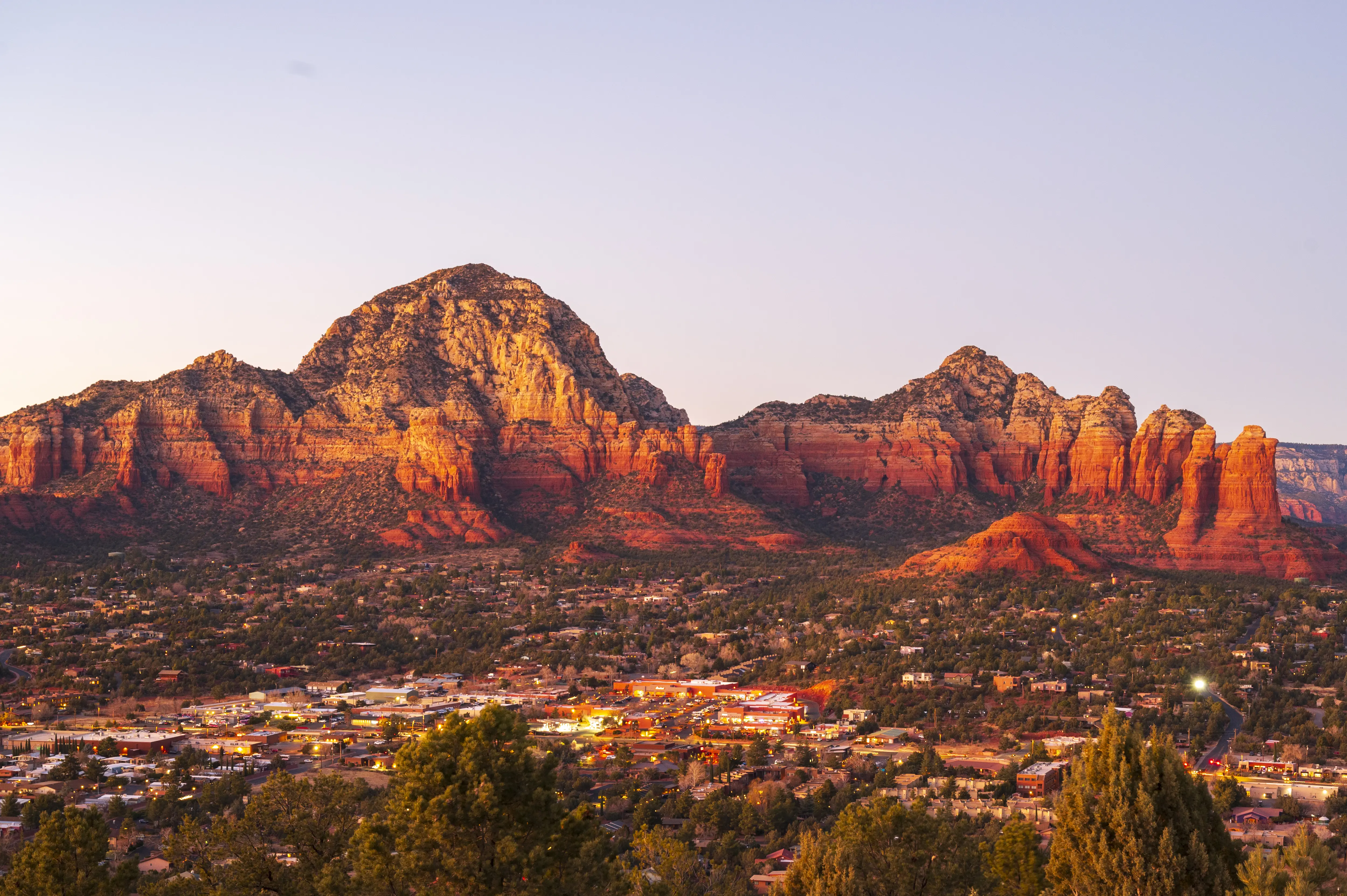Image of the town of Sedona, Arizona and its surrounding rock formations, taken at dusk.