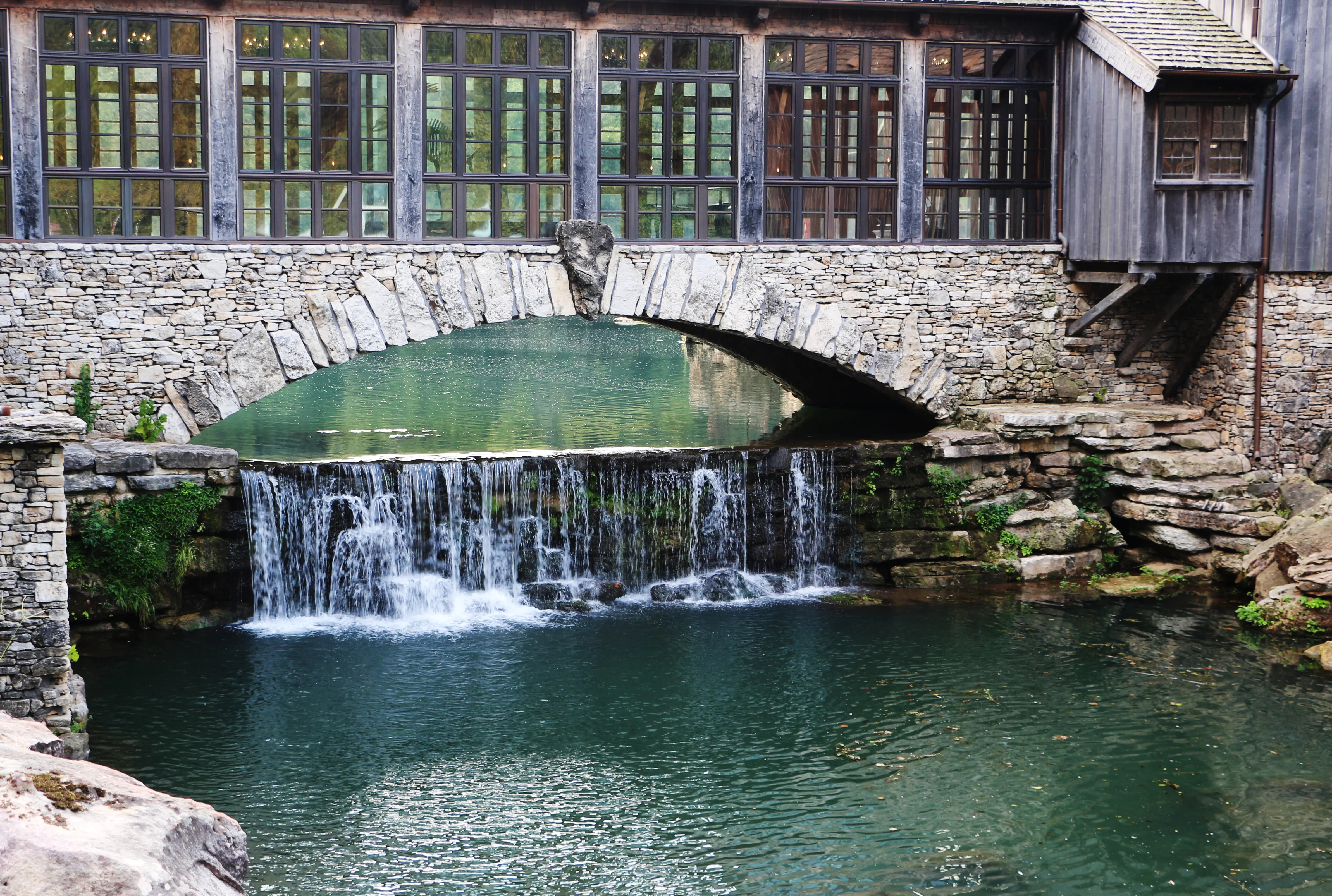 Gristmill close-up of stone bridge crossing over a small waterfall in Dogwood Canyon Nature Park, Missouri