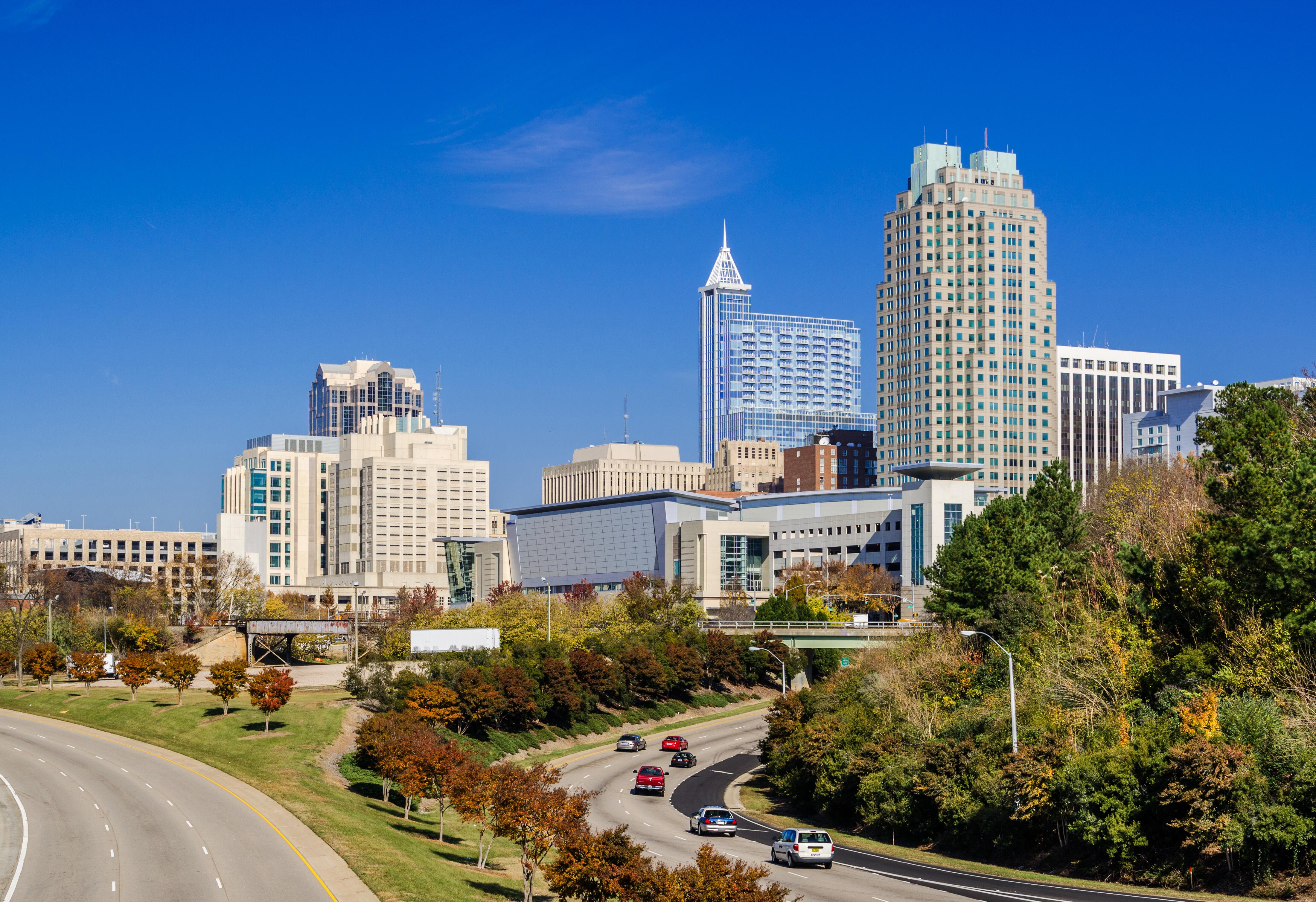 Raleigh downtown skyline view with Mcdowell Street and Dawson Street in the foreground, lined with Autumn colored trees.