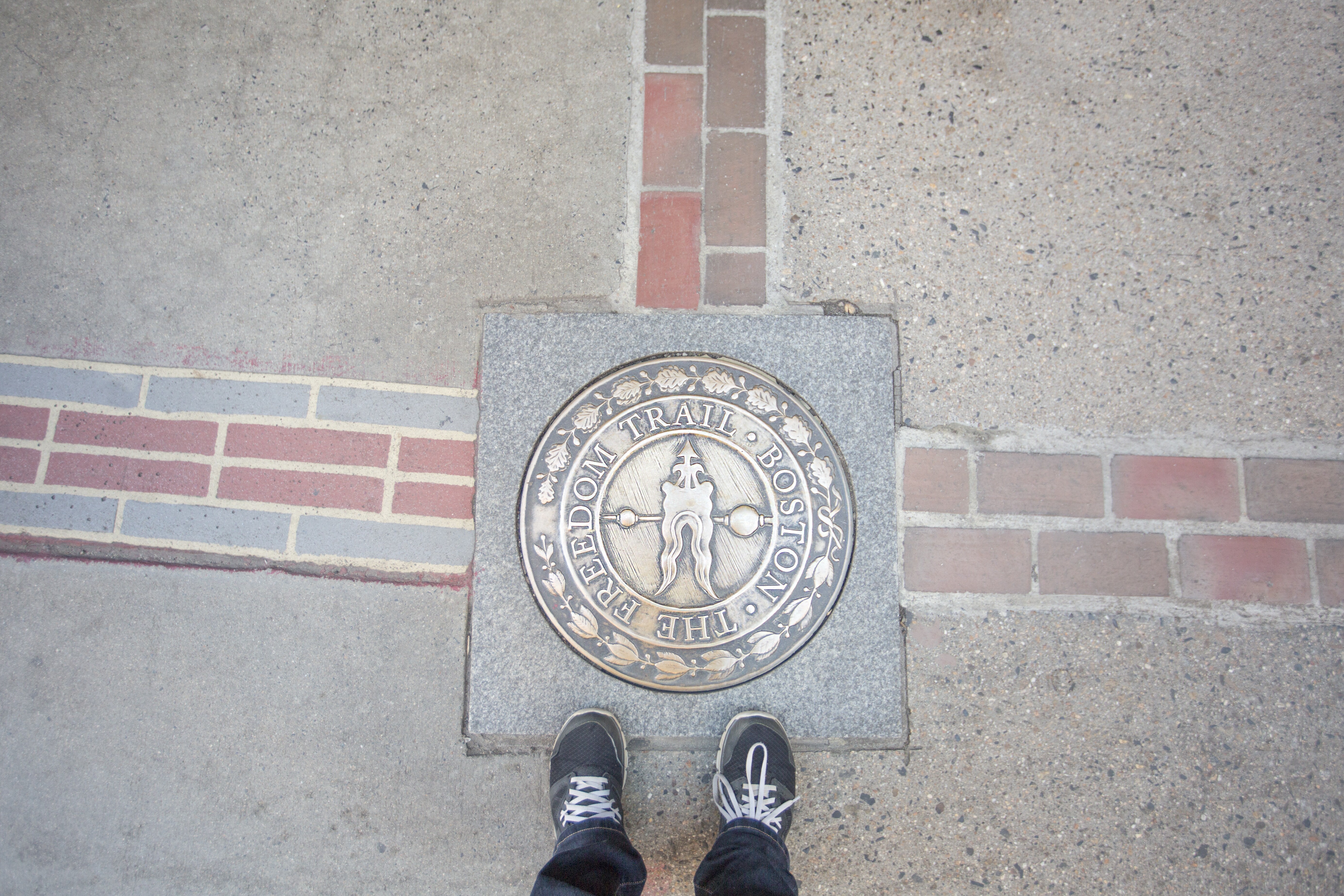 Image of the Freedom Trail marker in the ground, in Boston.
