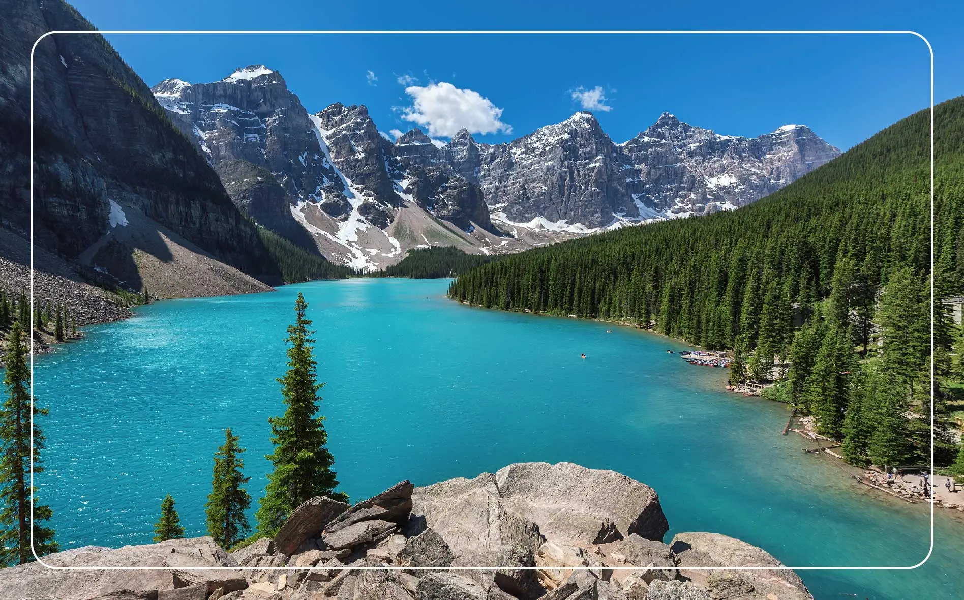 Beautiful turquoise waters of Emerald Lake with snow-covered peaks above it in Yoho National Park.