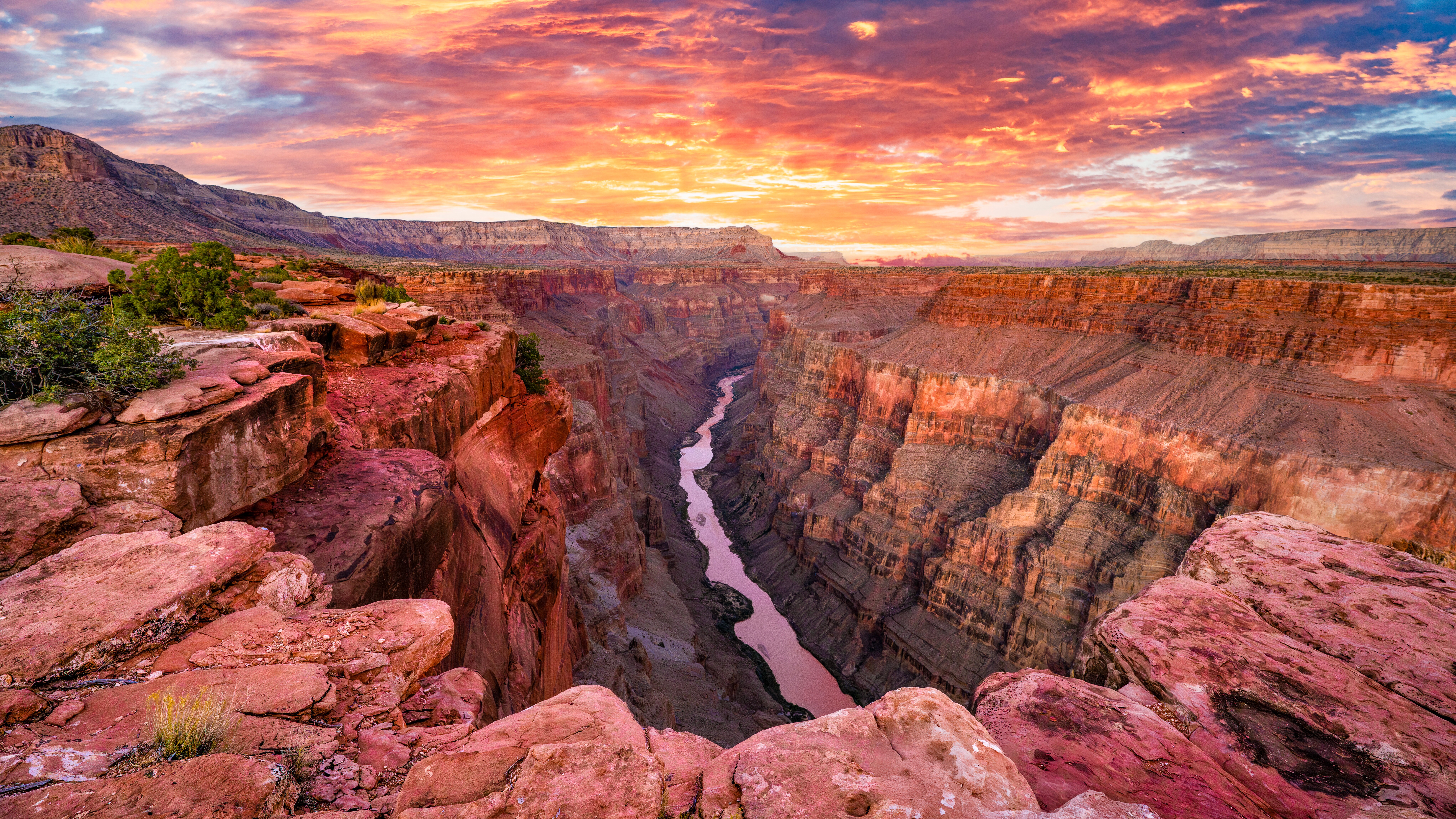 Colorful pink hue sunrise at Toroweap Lookout on the North Rim of the Grand Canyon, with dramatic cliffs and deep canyons, looking down at the Colorado River, creating a mesmerizing natural wonder