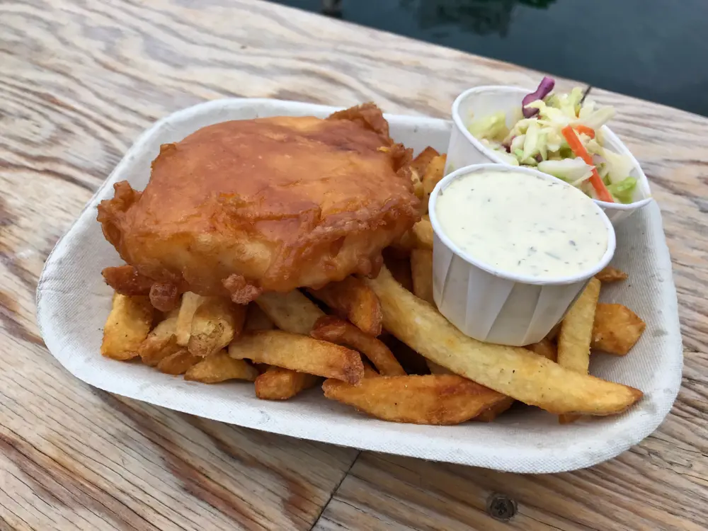 Container of fish and chips with a side of coleslaw and tartar sauce at Red Fish Blue Fish in Victoria, British Columbia.