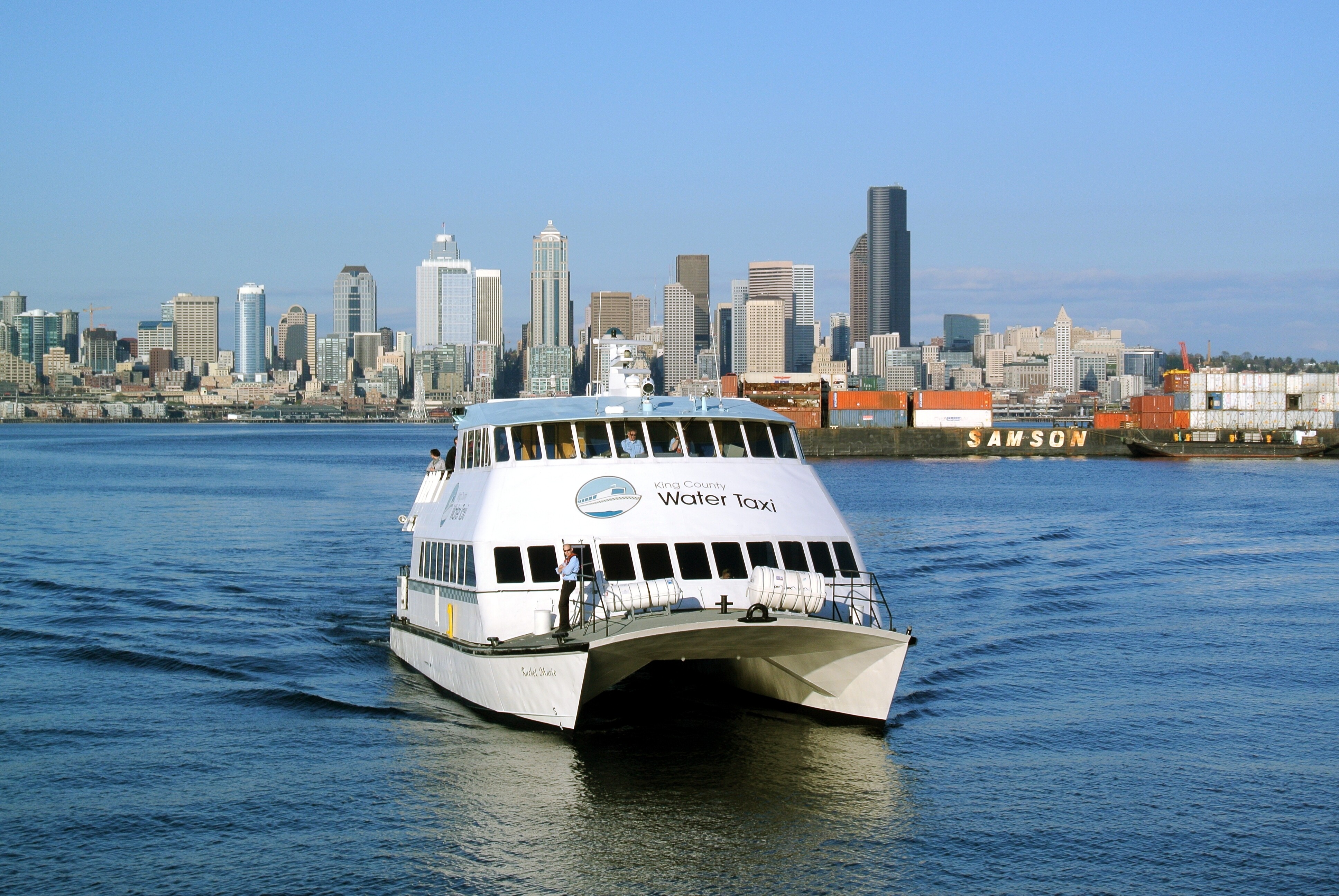 Image of a water taxi sailing in front of the Seattle skyline.