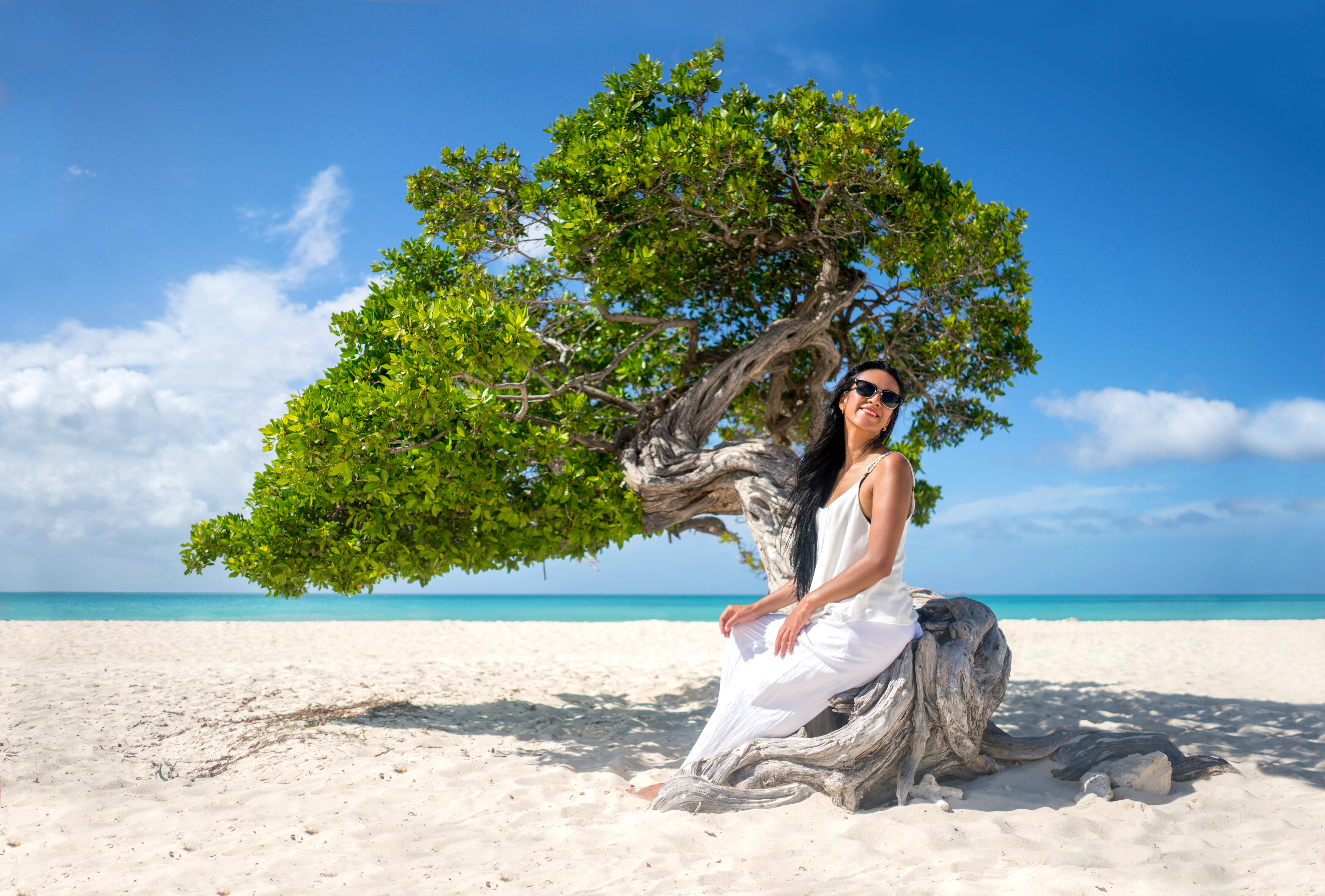 Young woman relaxing on a fotofi tree at the beach
