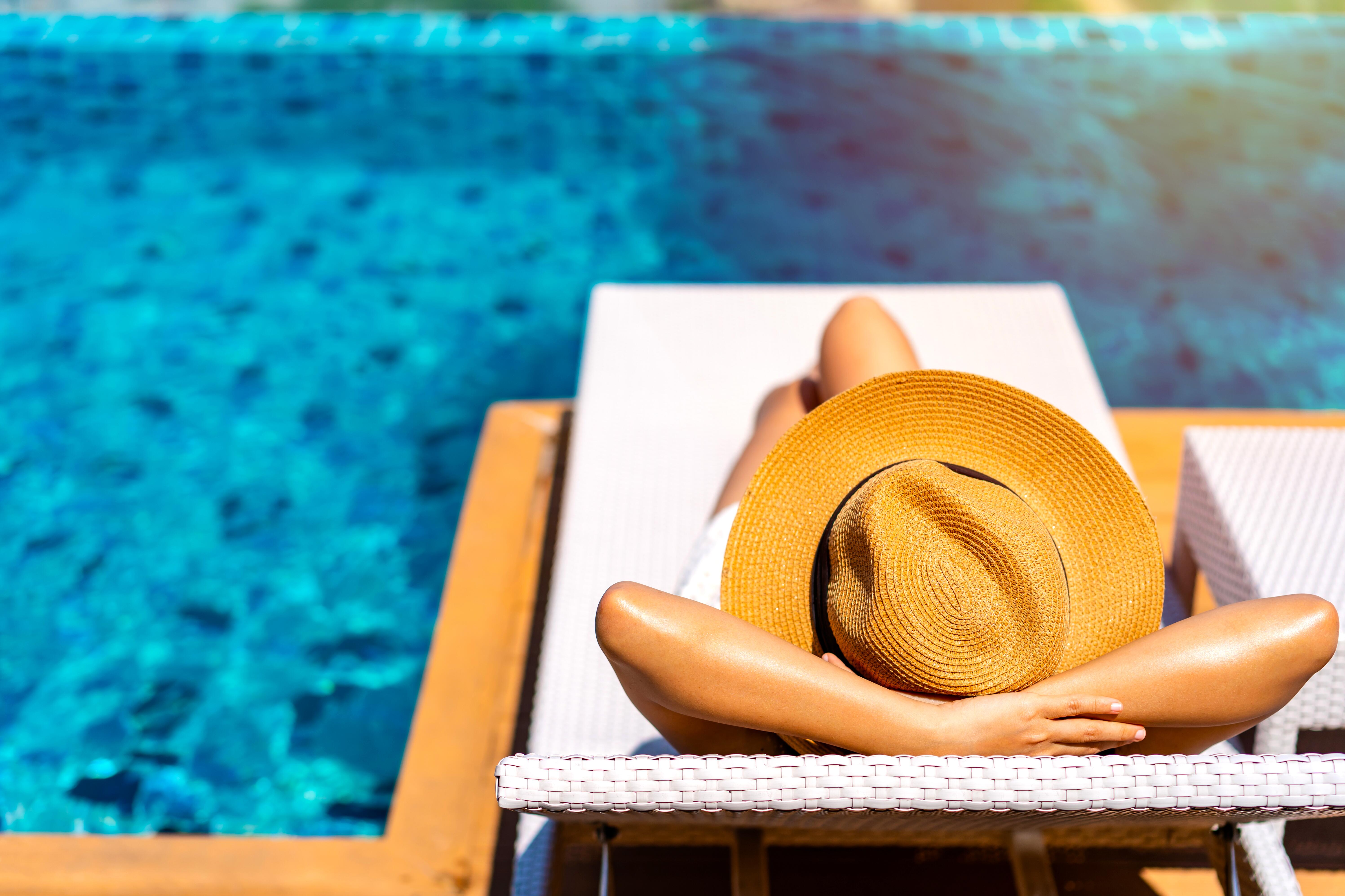 Female traveler relaxing for summer at a resort pool
