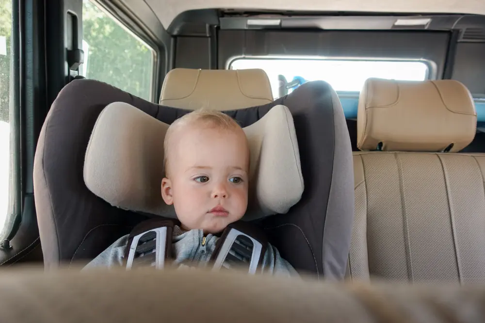 Baby in booster seat in vehicle