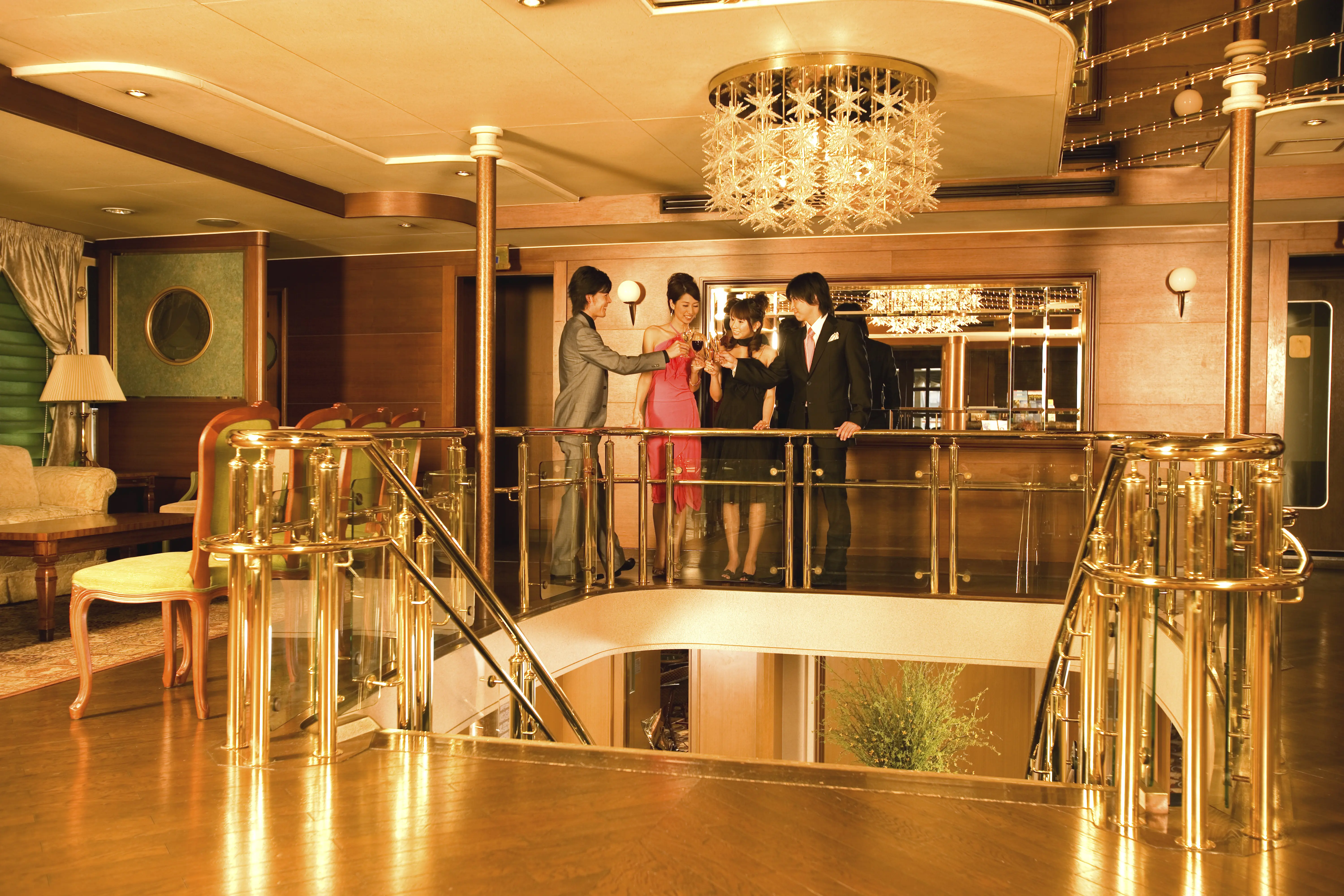 Image of a group sharing drinks together in a cruise ship lobby interior, with elegant and fancy furnishings.