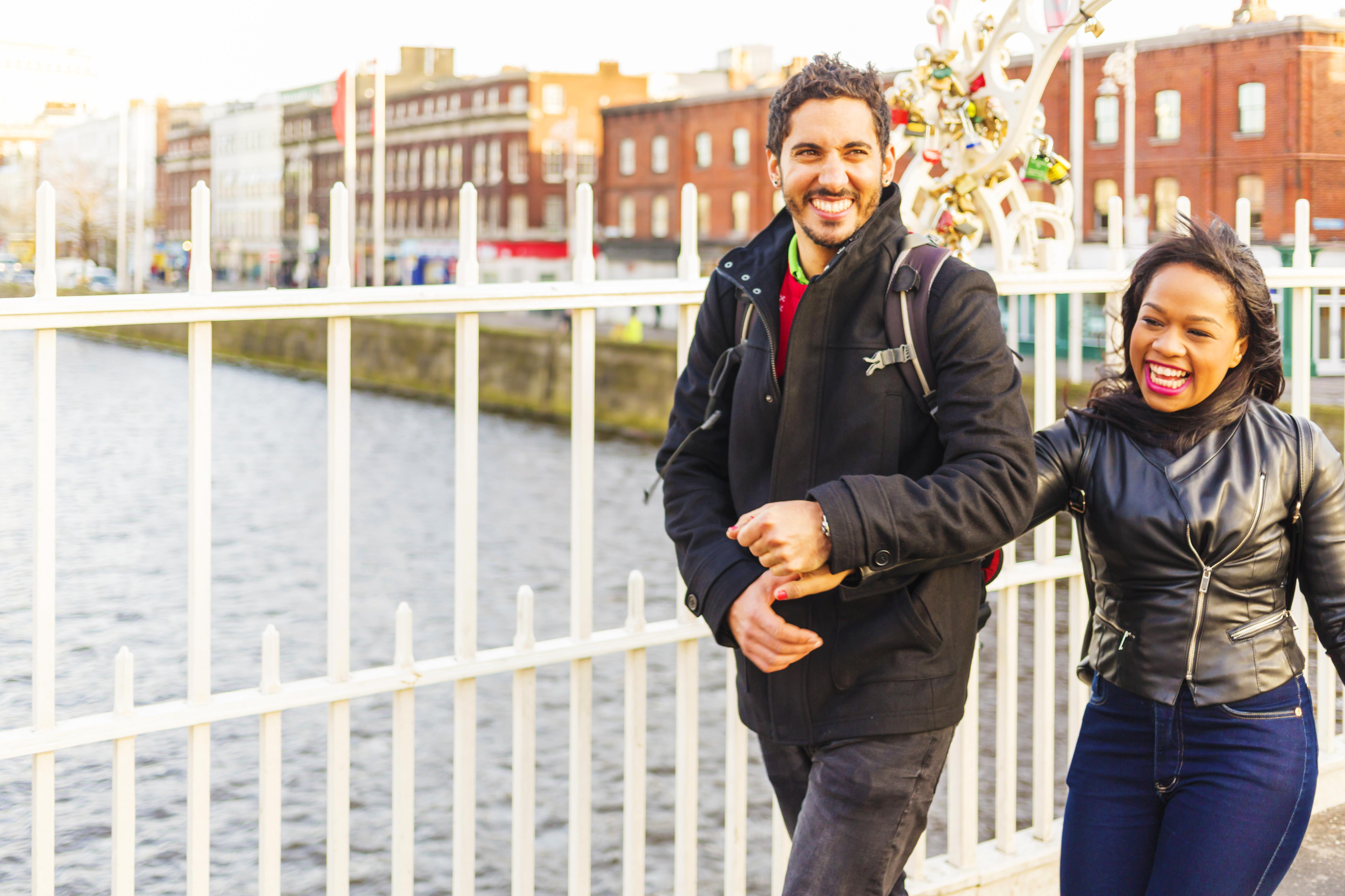 Happy, young couple strolling on Dublin’s Ha’penny Bridge during holiday