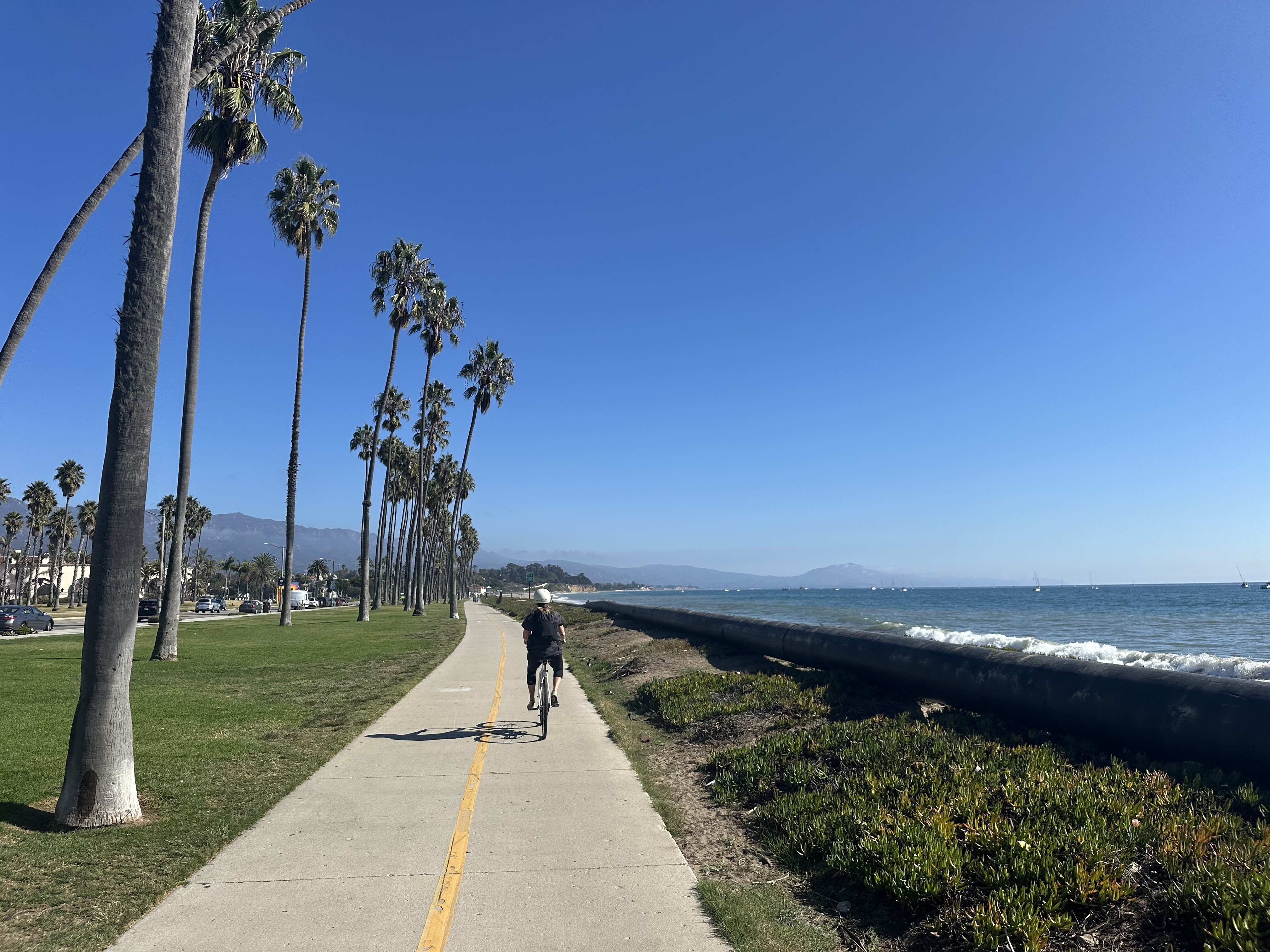 Woman with long blonde hair posed in front of small rocky waterfall.