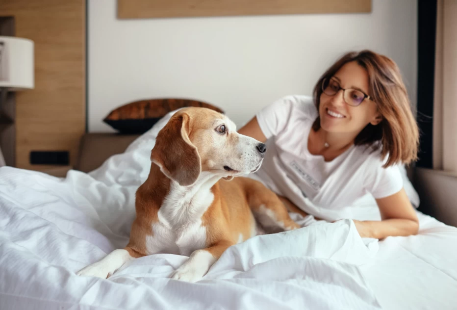 Woman with dog on bed.