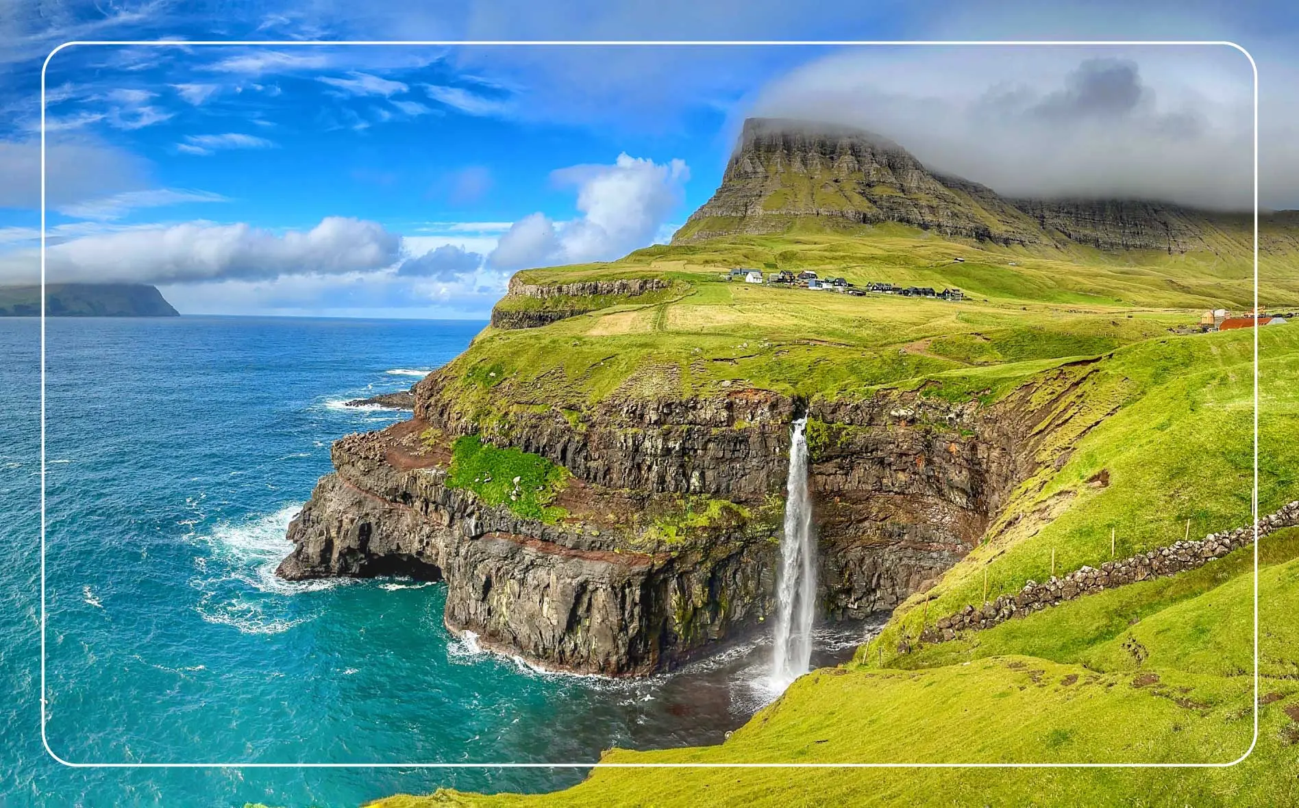 Sunny day at Múlafossur Waterfall near the Gasadalur village on Vágar, Faroe Islands.